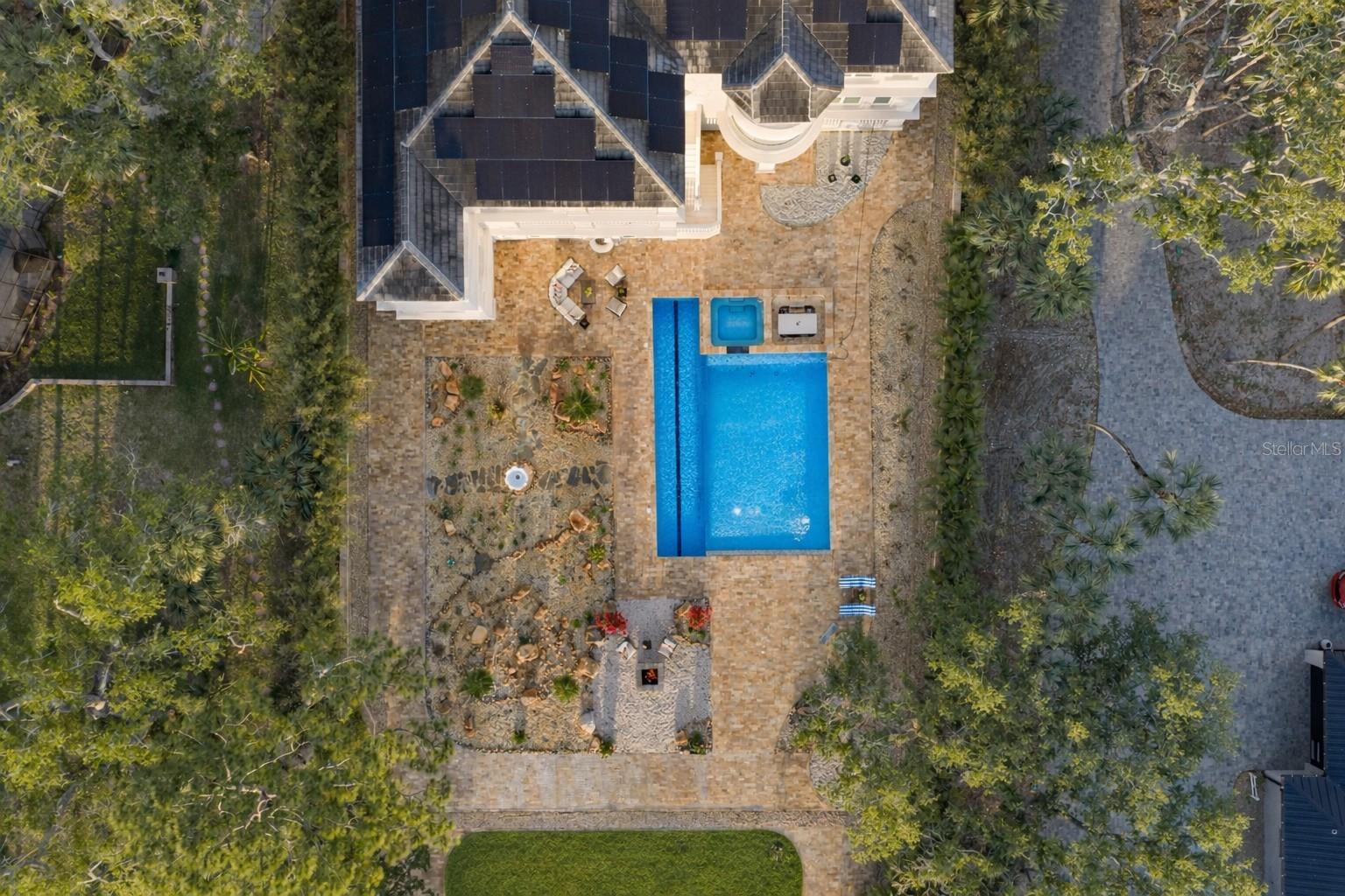 True private outdoor spaces, fire pit, palm inspired landscaping, citrus trees, a  beautiful half acre rear lawn, and private sandy beach.