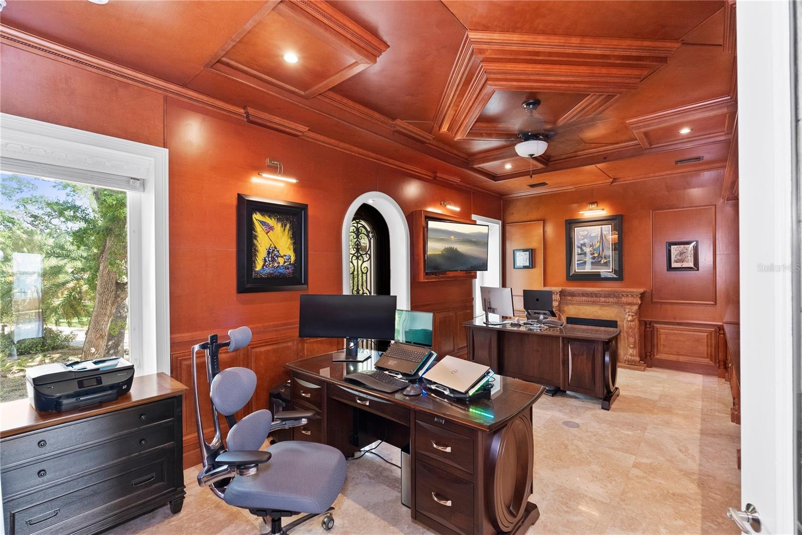 Private office with custom wood paneling, fireplace, and balcony access.