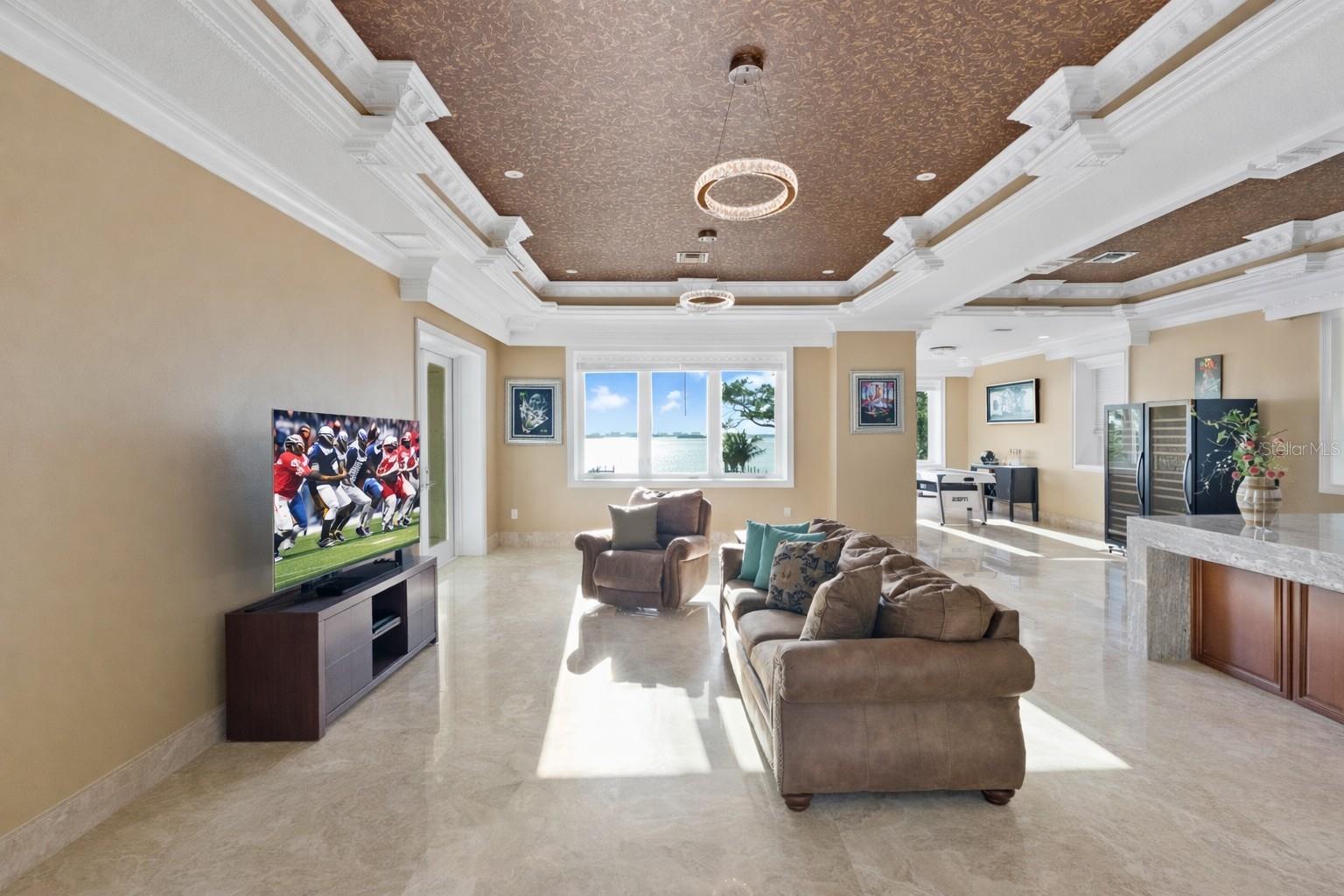 A statement space defined by dual coffered ceilings and the scale to create your ultimate game or entertainment lounge. Grand-scale room featuring dual coffered ceilings and endless possibilities for entertaining.