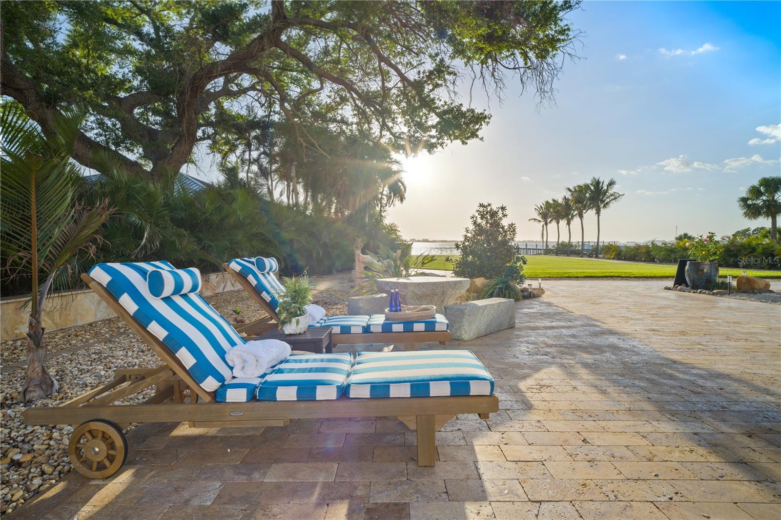 Expansive poolside setting with multiple lounging areas across beautifully landscaped grounds.