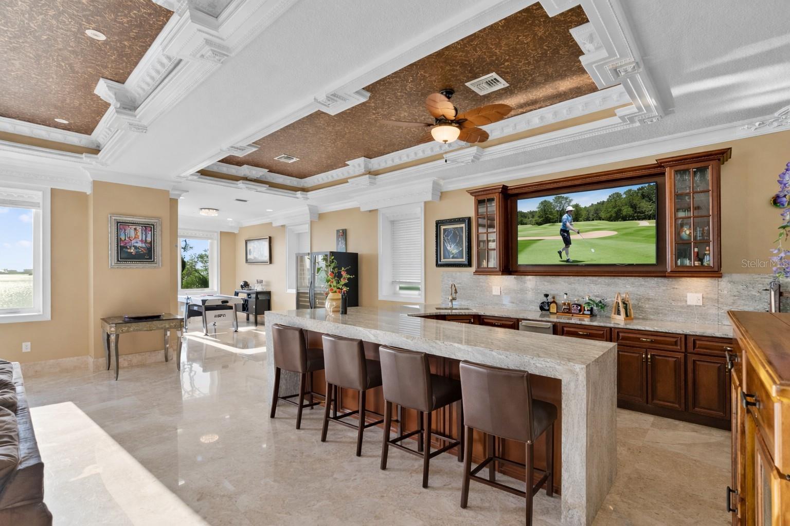 Club-style lounge with waterfall quartzite bar and elevated sunset views.