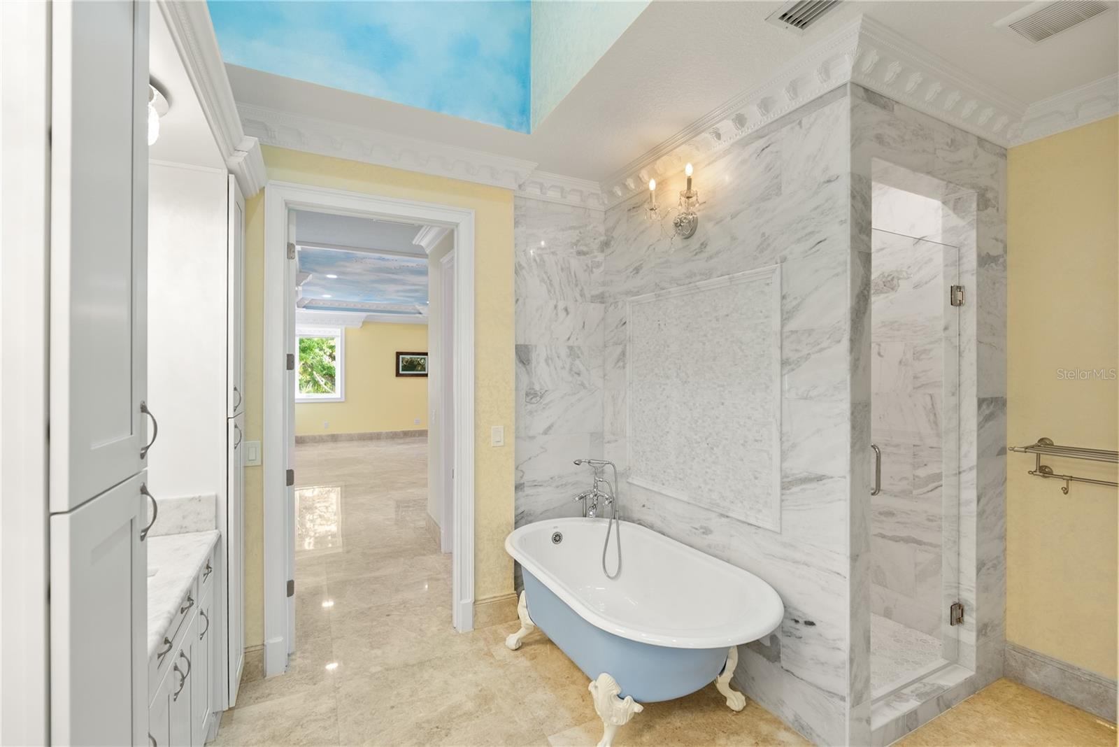 A timeless clawfoot soaking tub anchors this spa-inspired guest retreat.