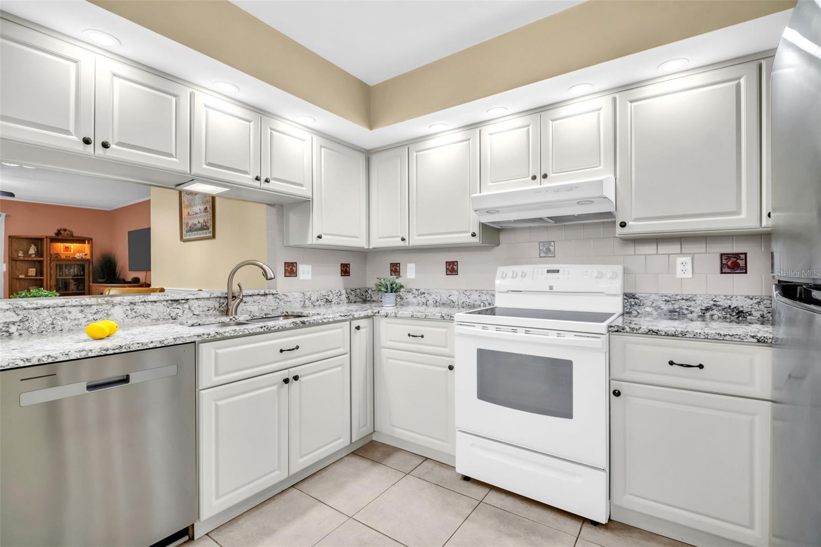 Granite countertops, solid-wood cabinetry, and recessed lighting~