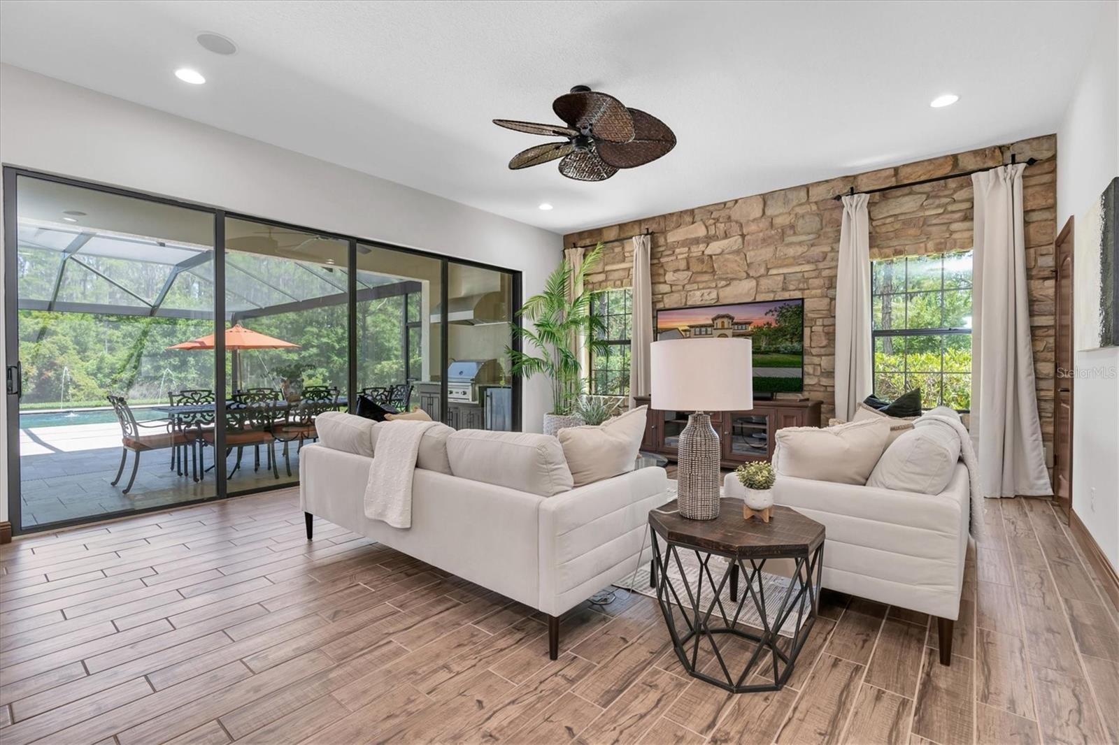 GATHER IN THE GRAND ROOM ANCHORED BY CUSTOM STONE ACCENT WALL