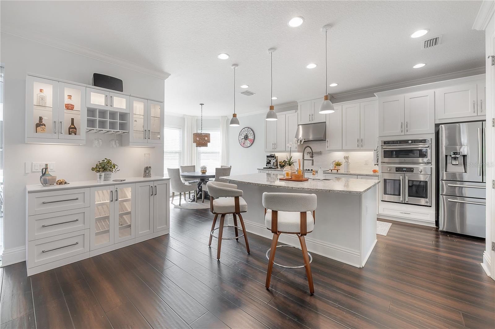 The heart of the home features a gourmet GE Café chef’s kitchen, a sleek dry bar, and a sun-drenched breakfast nook perfect for morning coffee.