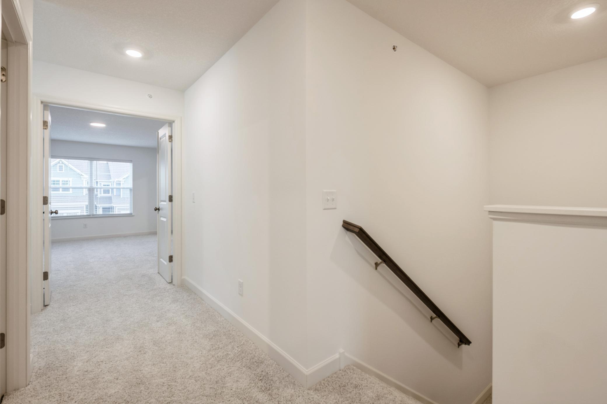 (Photo of a similar home, actual homes finishes will vary) Upper level landing.