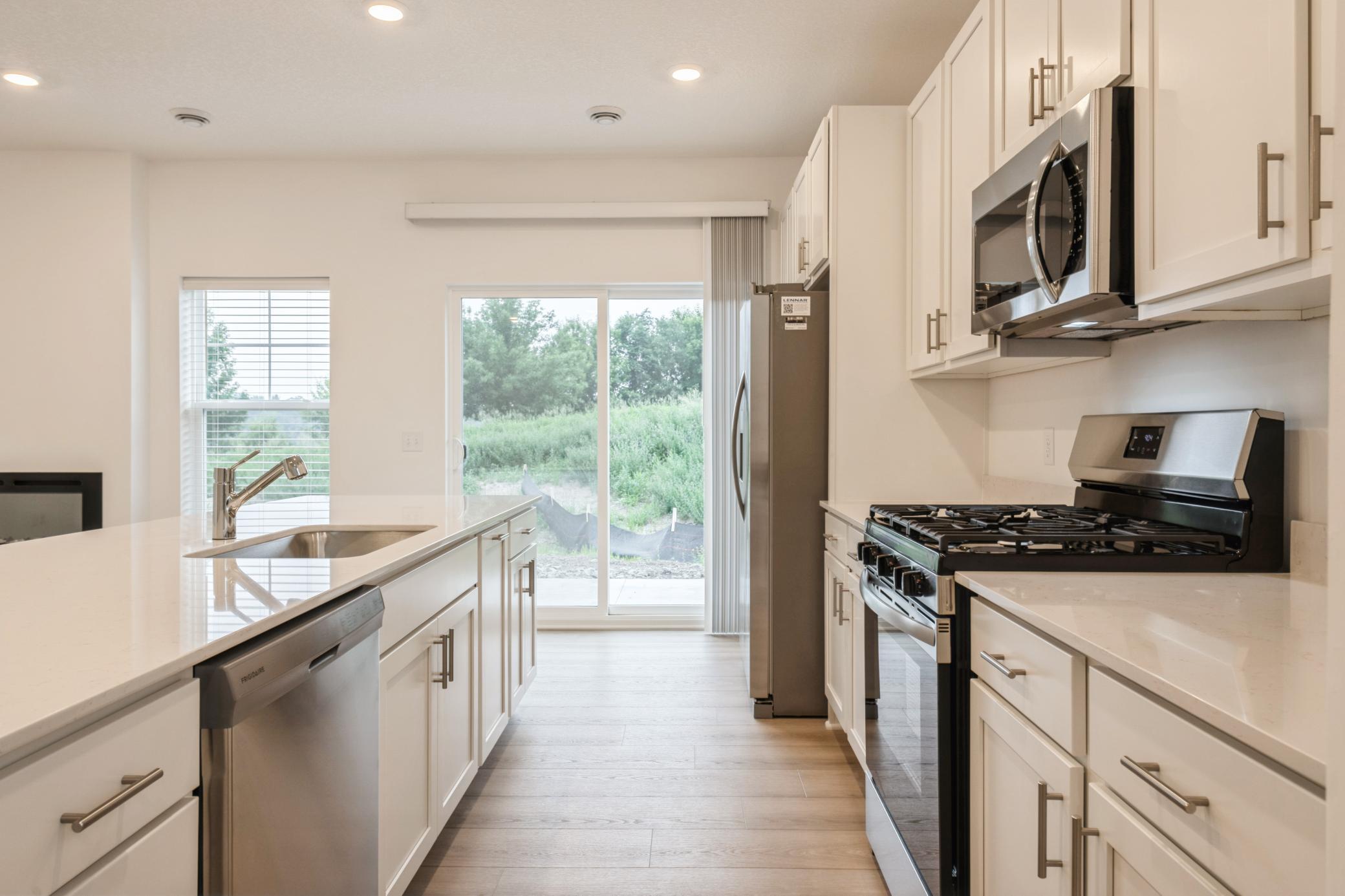 (Photo of a similar home, actual homes finishes will vary) Spacious kitchen opens to the patio.