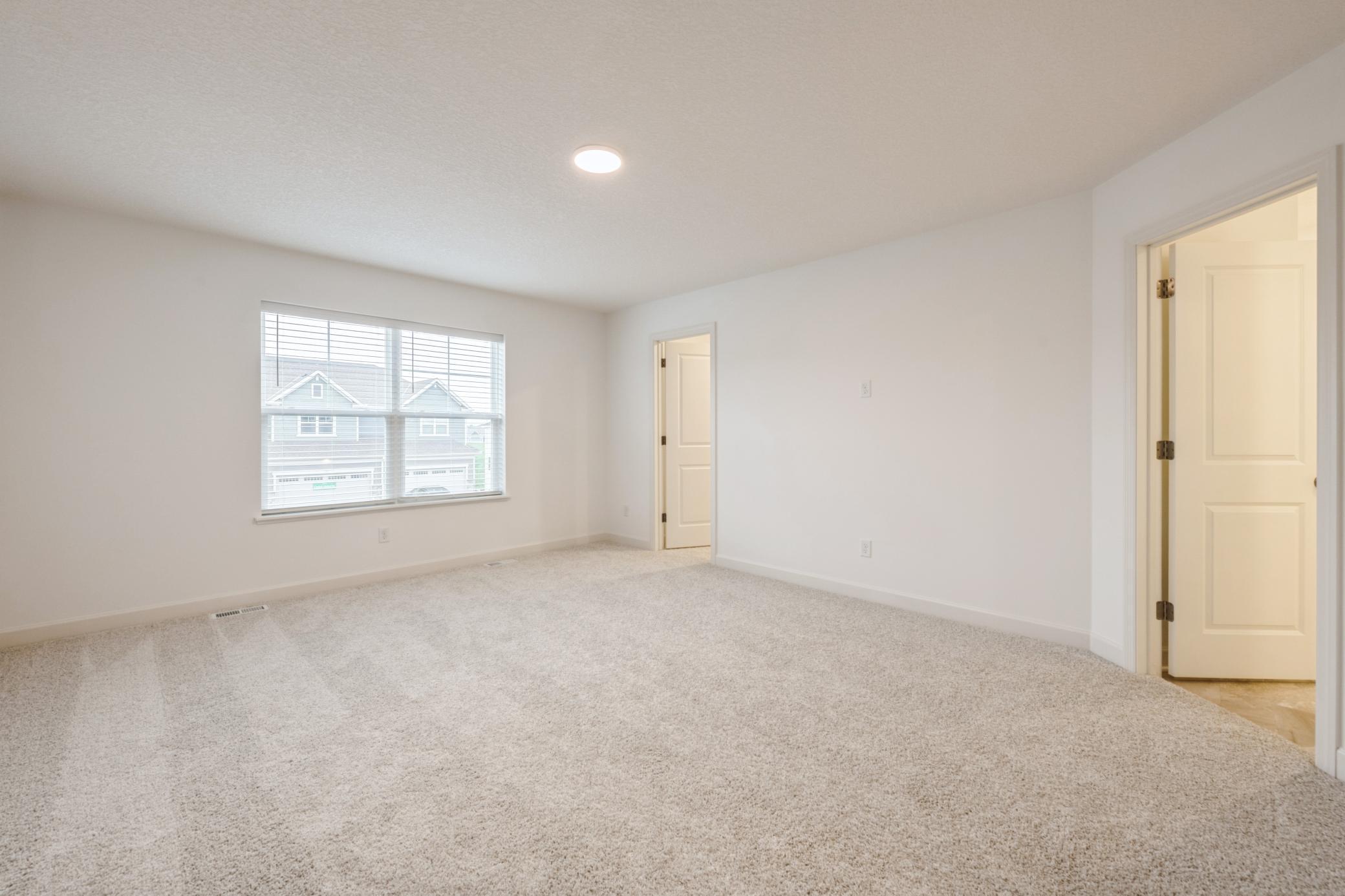 (Photo of a similar home, actual homes finishes will vary) Spacious primary suite with an abundance of natural light!