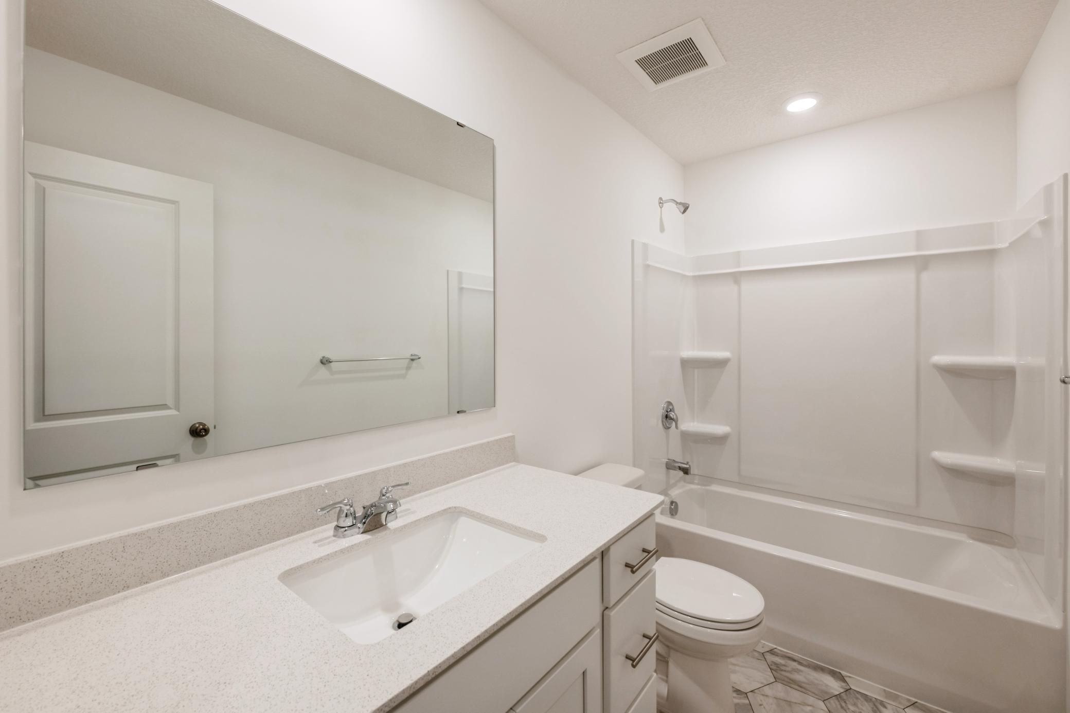 (Photo of a similar home, actual homes finishes will vary) This spacious upper level bath provides plenty of space for everyone to get ready during those busy mornings.