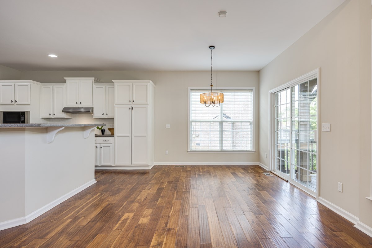 Eating area with new light adjacent to kitchen and great room and deck access.