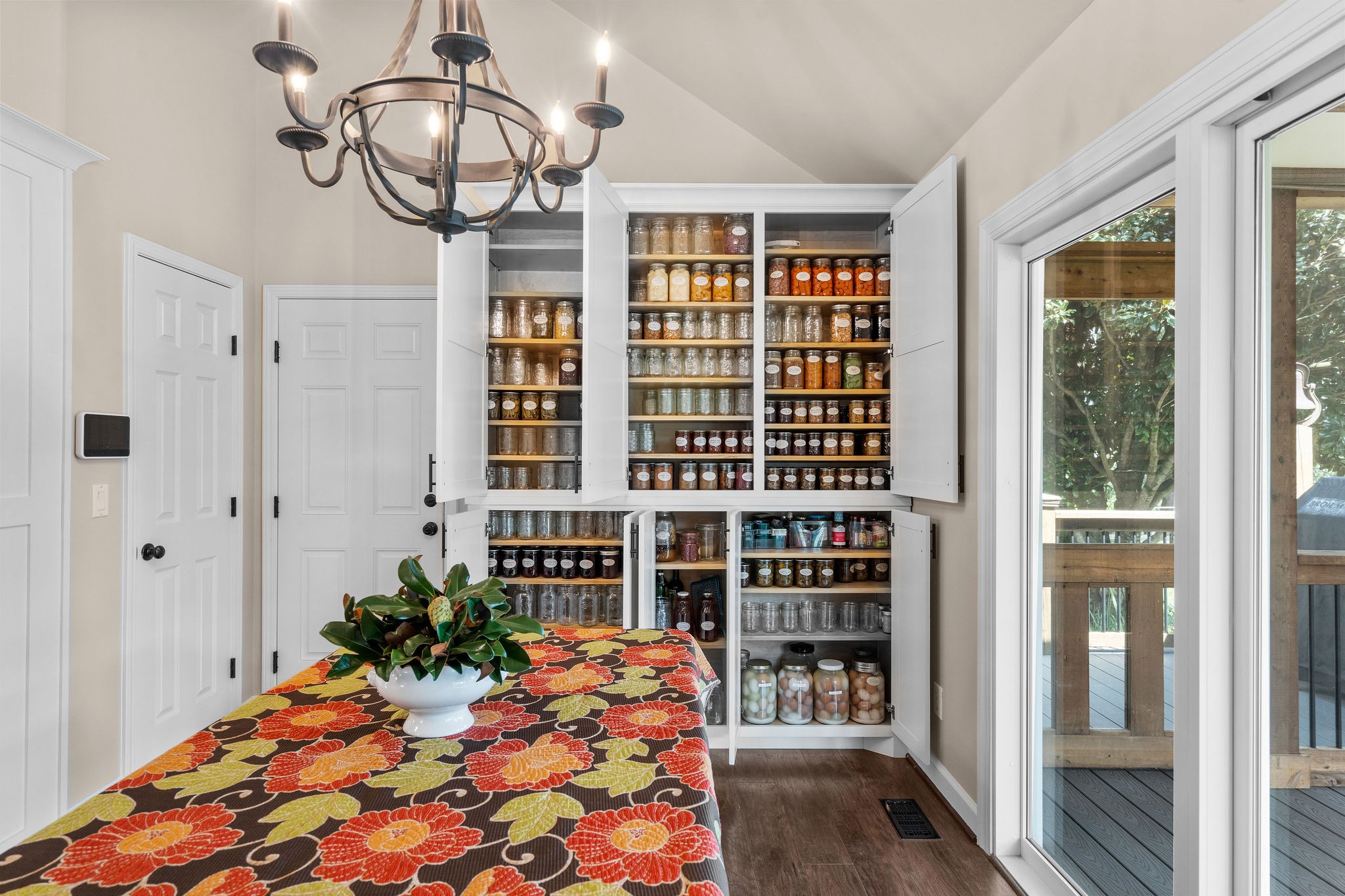 When opened, you can appreciate how much storage the large custom-made pantry offers! Pictured here is some of the fruit and vegetables grown on this property that was canned and preserved by the sellers.
