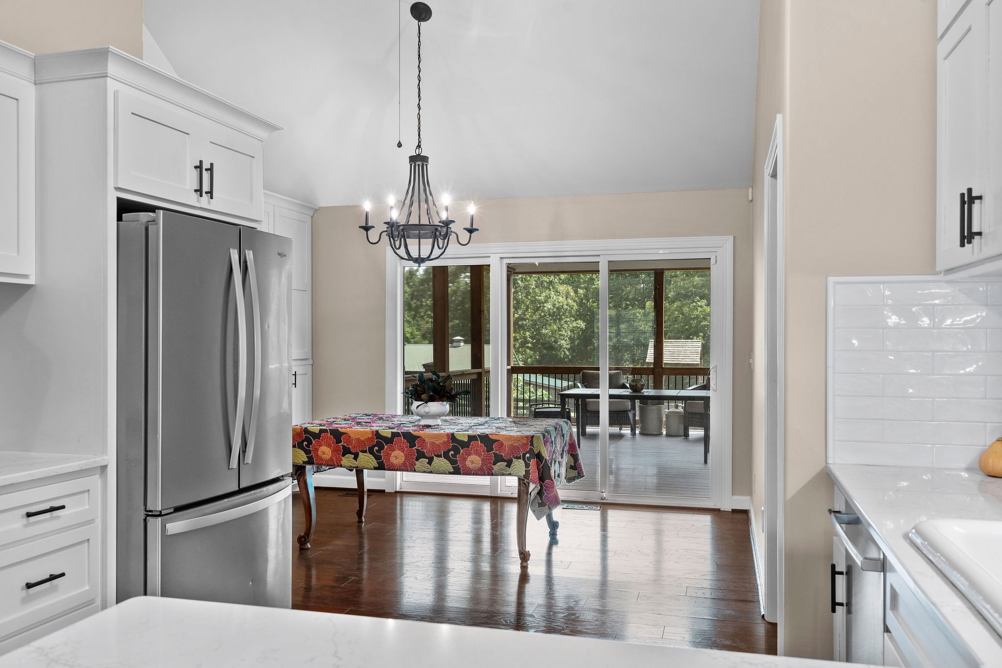 A view through the kitchen to the dining area, and the screened outdoor room beyond the sliding glass wall. Beautiful!