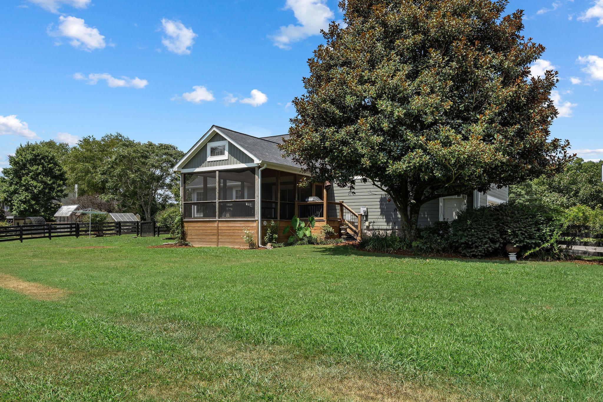 This view from the backyard shows the two greenhouses in the garden area.