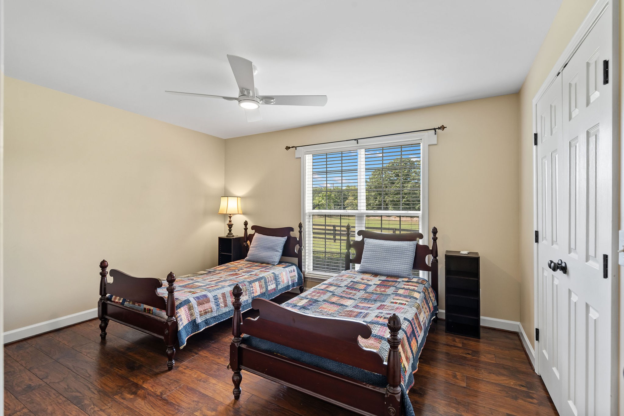 Bedroom 2 of 3 is also located on the first floor and features the same wood flooring found throughout the house. A large window looks onto the front yard, pasture and woods beyond. The home’s interior has been recently painted.