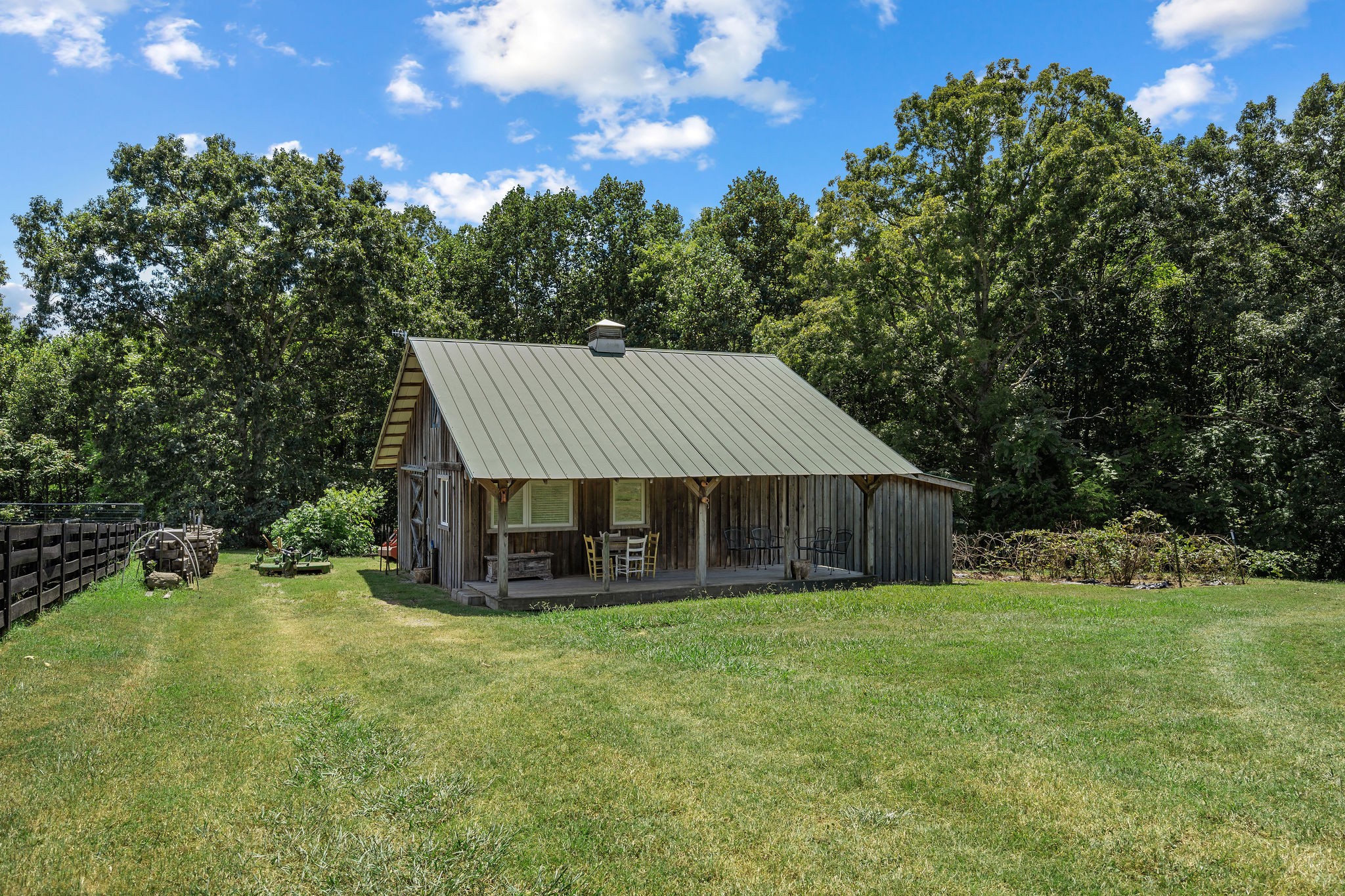 The barn with the trellis blackberry bushes to the right. Two of five fig trees can be seen behind the barn to the left.