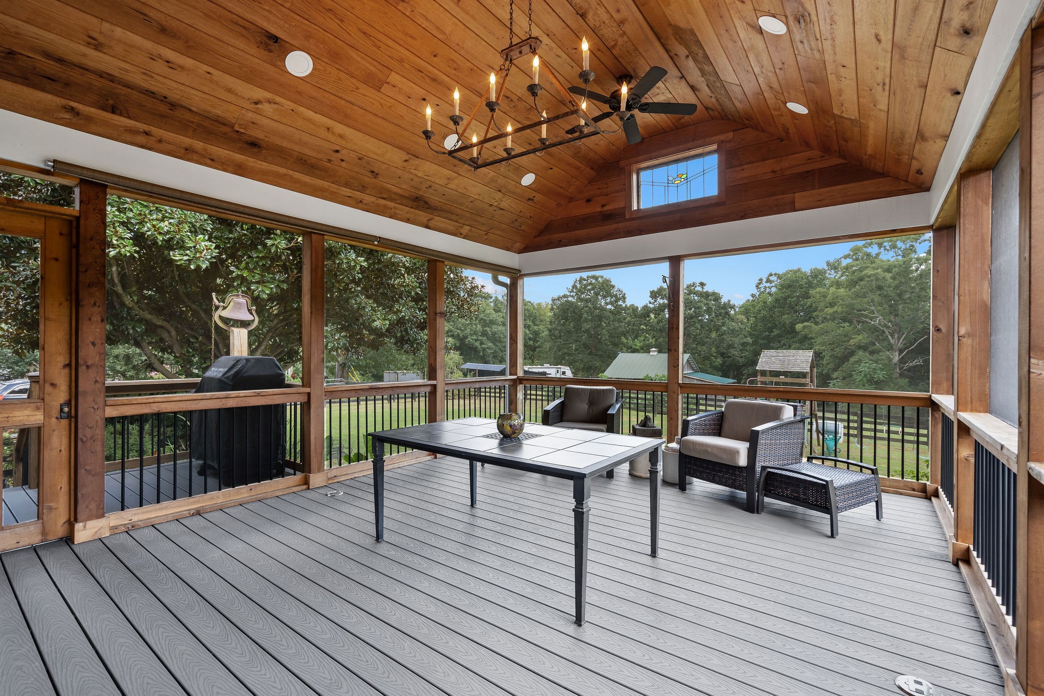 The huge screened in outdoor room is pure heaven! The oak ceiling and cedar post were milled in Leipers Fork for this home. The antique stained glass wndow is reminiscent of the flowers, fruit, and vegetables grown on the property.