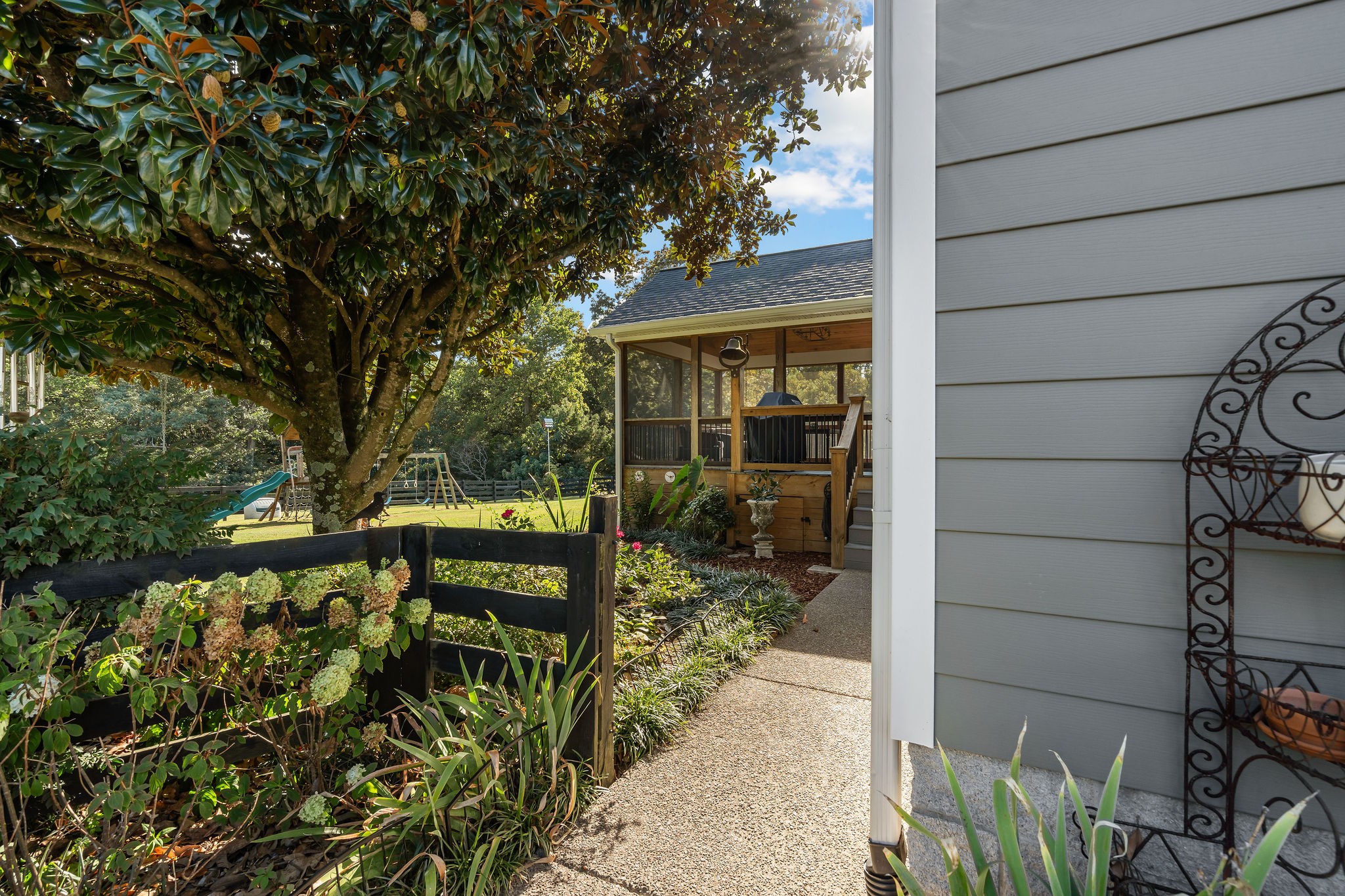 The walkway from the driveway to the screened outdoor room is landscaped with a selection of low maintenance hydrangeas, irises, roses, azaleas, liriope and TN natives.