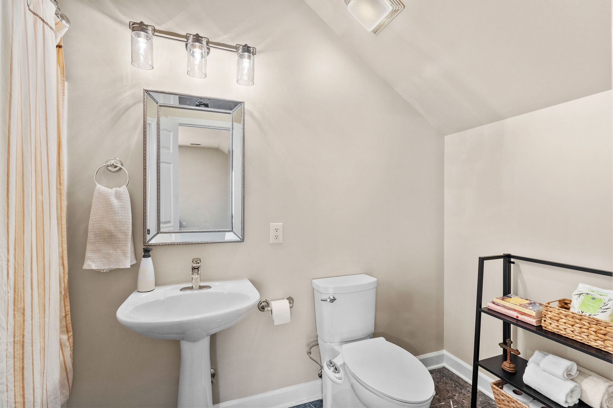 The upstairs full bath features new paint and lighting, marble flooring, and a combination bath tub/shower.