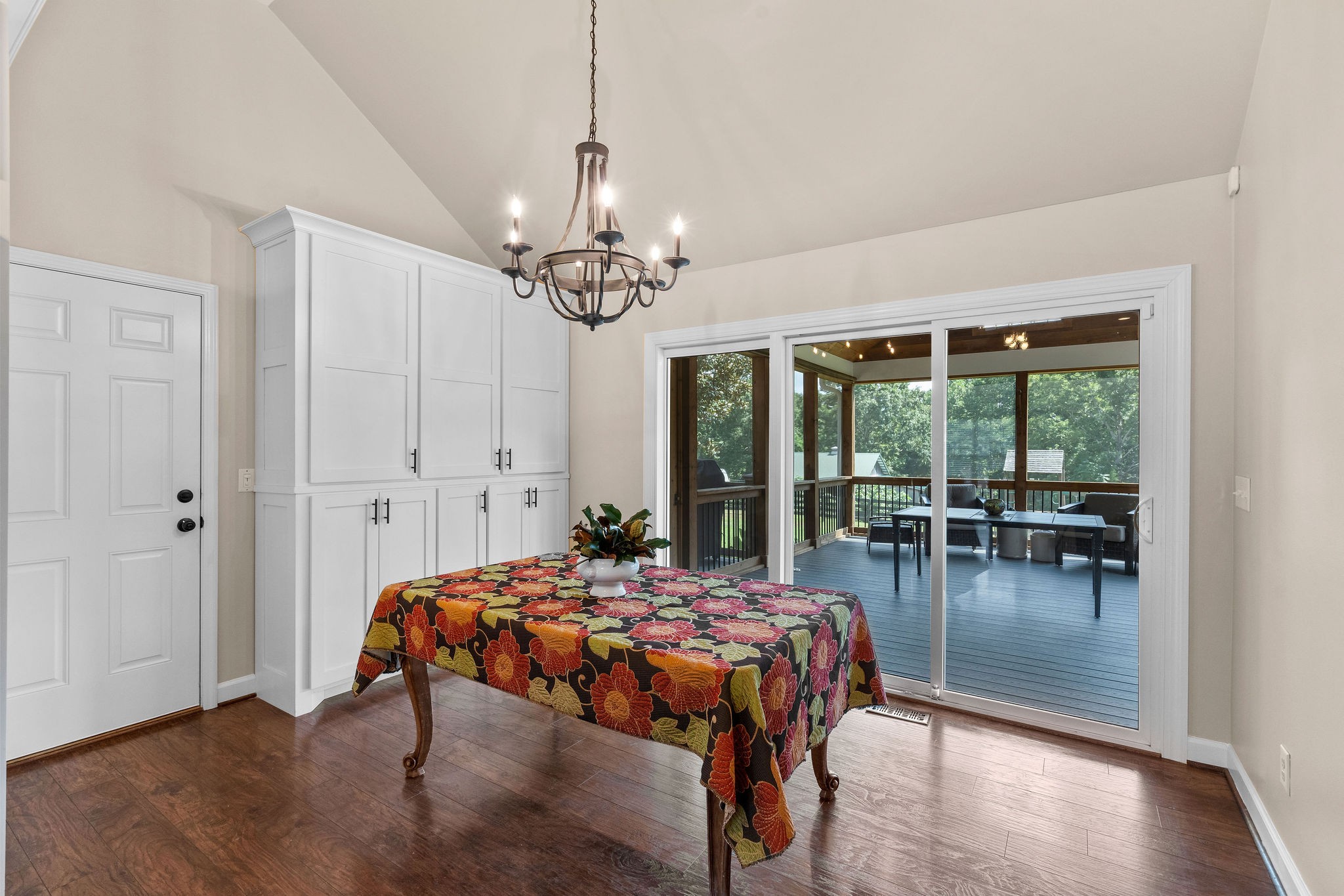The dining area opens to the huge outdoor screened room which is perfect for entertaining. The vintage inspired iron chandelier adds a charming farmhouse touch.