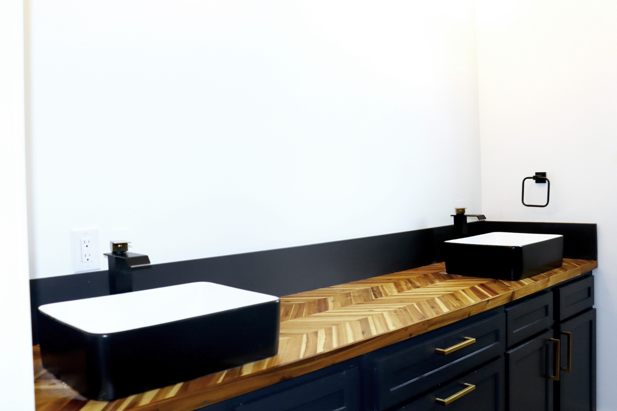 Double vanities in the Primary Bathroom with herringbone pattern wood counters.