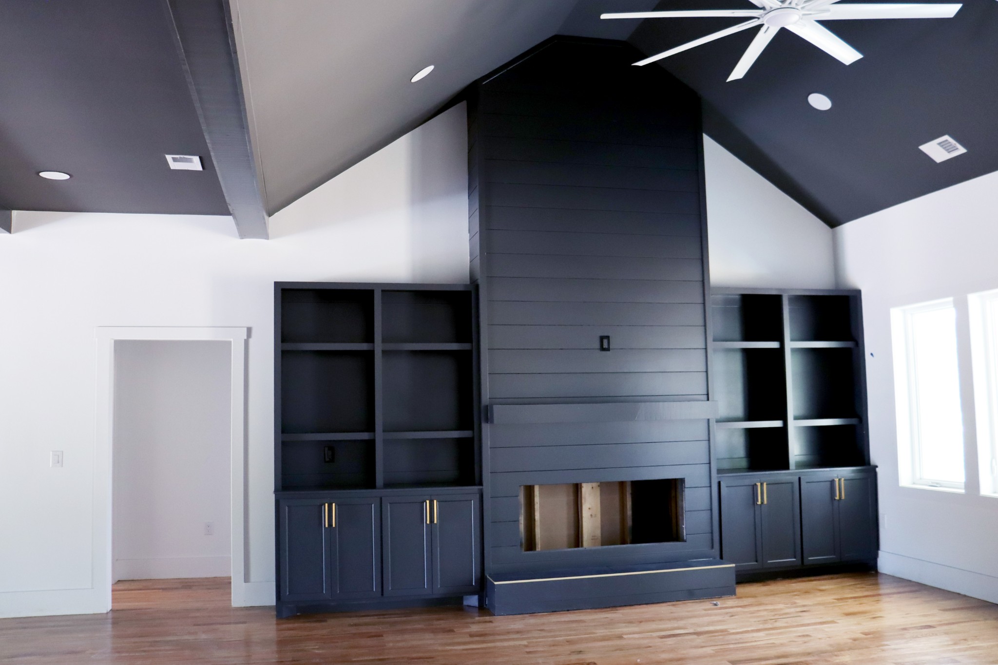 High soaring ceilings with open exposed beams accentuate the fireplace.