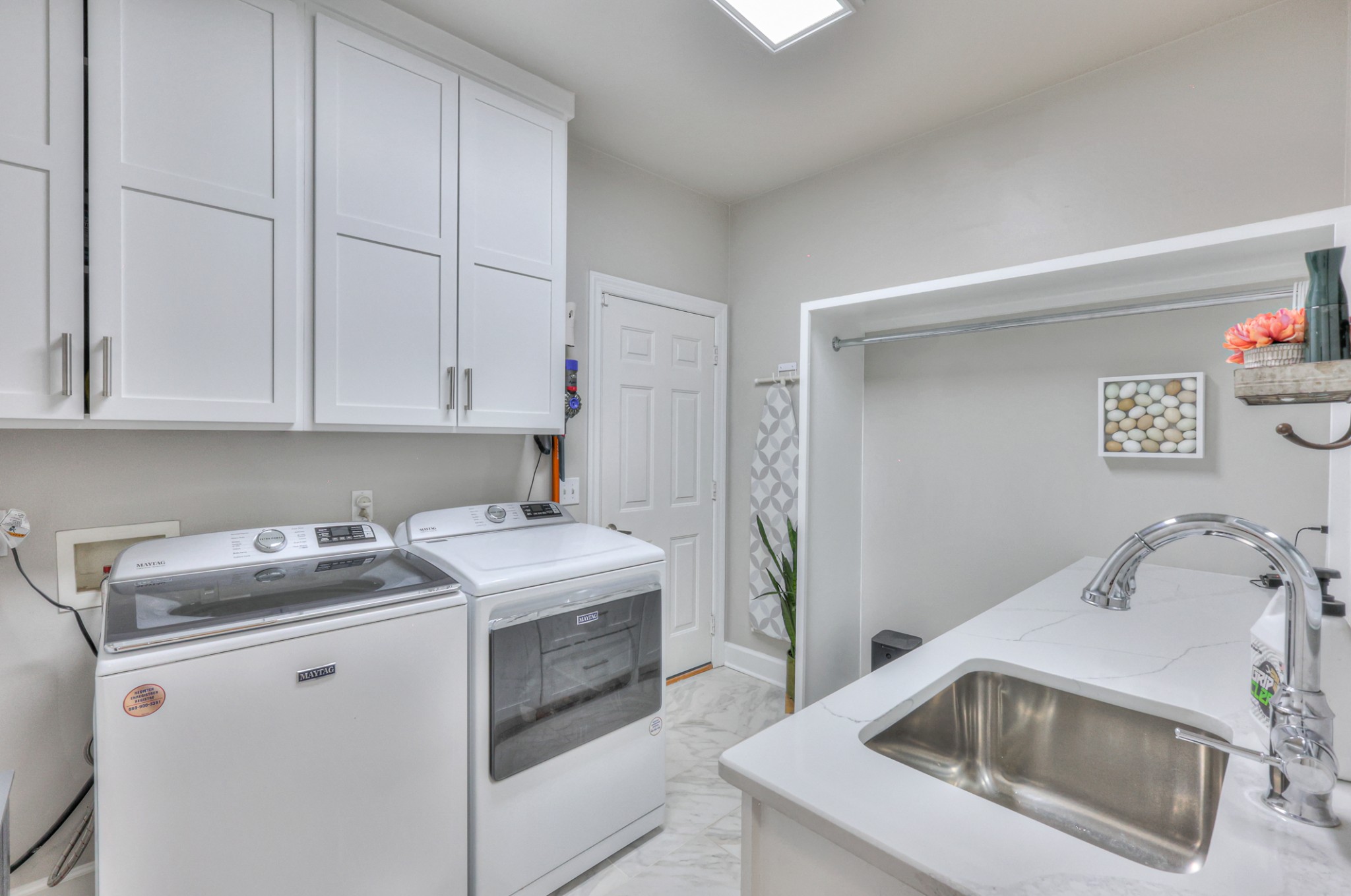 Designer laundry room with plenty of room to hang clothes fresh out of the dryer. Door leads to two car attached garage.