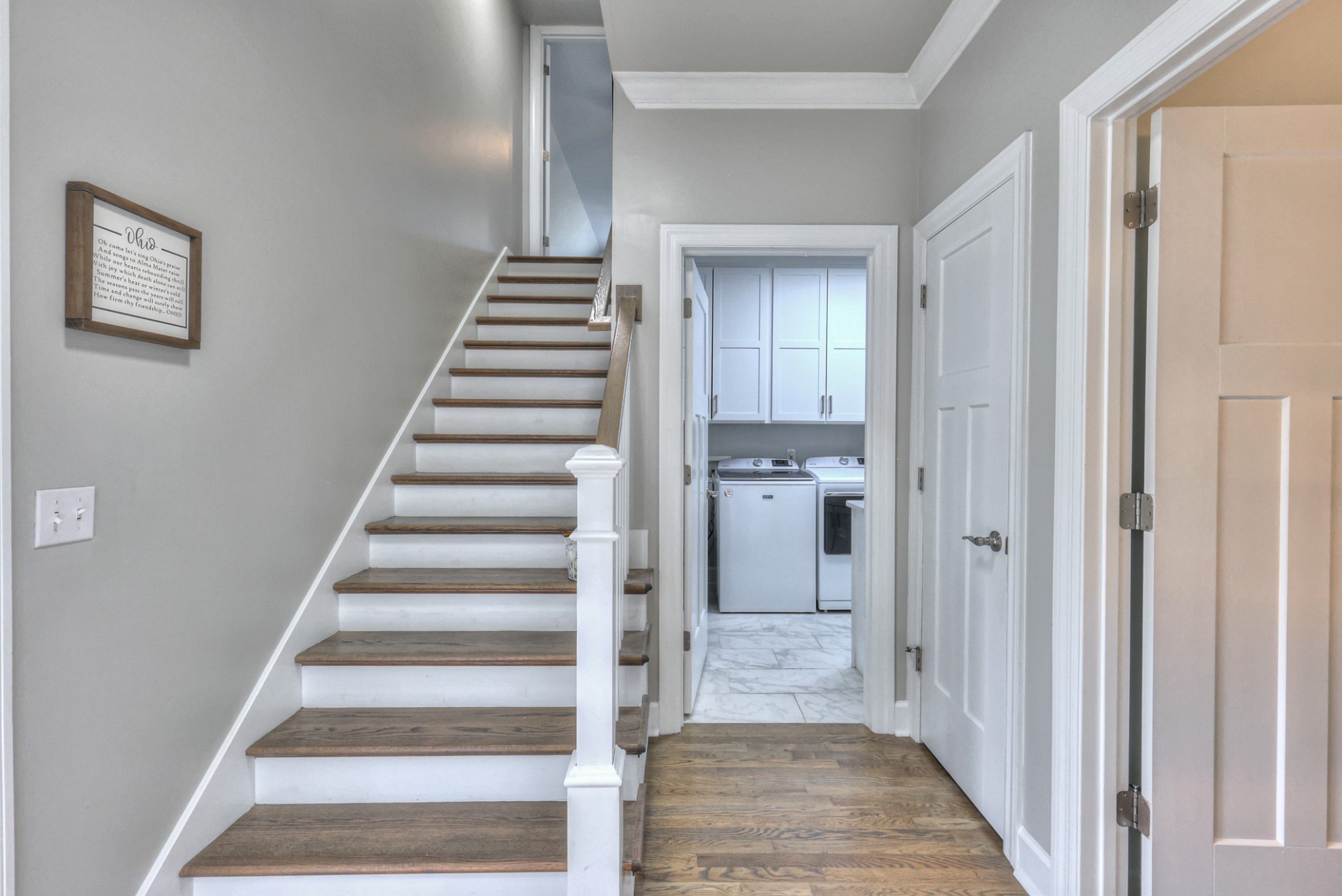 Stairway to bonus room on left. Laundry room and entrance to garage in the middle. Full bath on main floor to the right