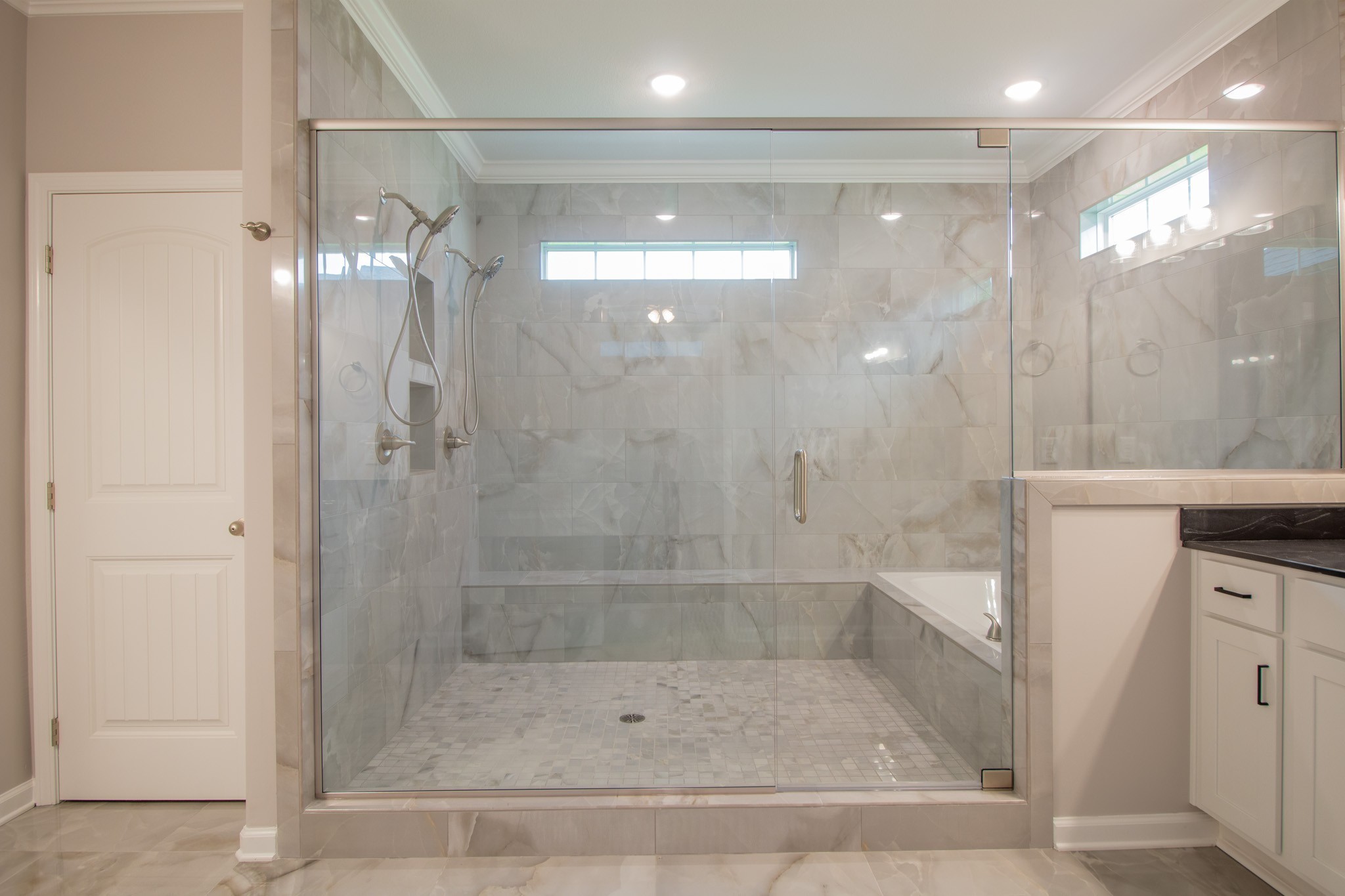Primary Bathroom with a Luxurious Walk-in Tile Shower with 2 Shower Heads and a Soaker Tub, All Enclosed Behind Glass!