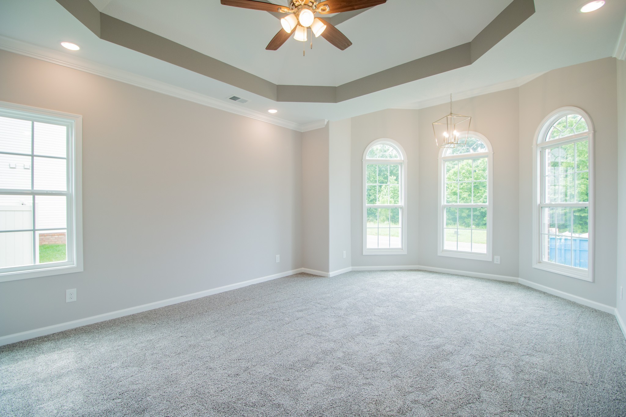 Primary Bedroom Features a Sitting Area, Double Tray Ceiling, Crown Molding and Recessed Lighting!