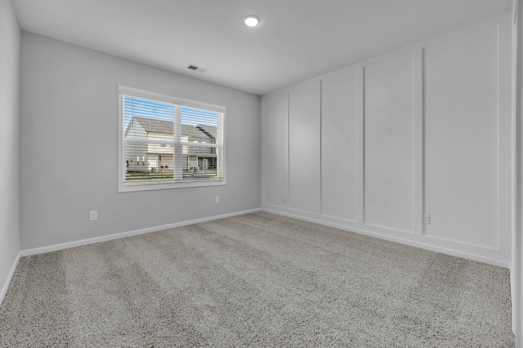 Spacious Primary Bedroom Downstairs Featuring Judge's Panelling Accent Wall! The View from this Bedroom will Overlook a Beautiful Pond Located on the neighboring City-Owned parcel.