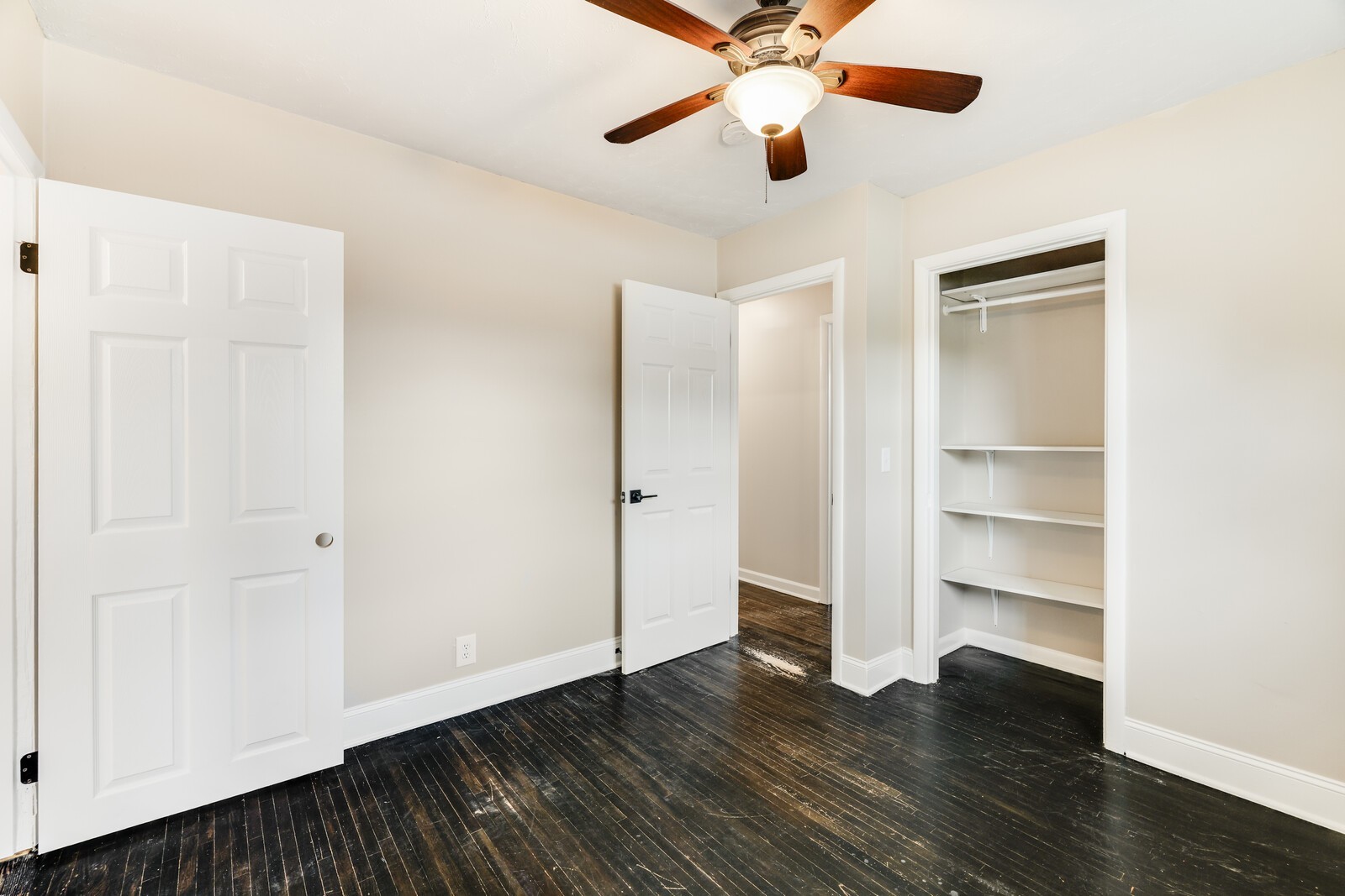 Bedroom 2 with hardwood floors, closet with shelving and ceiling fan