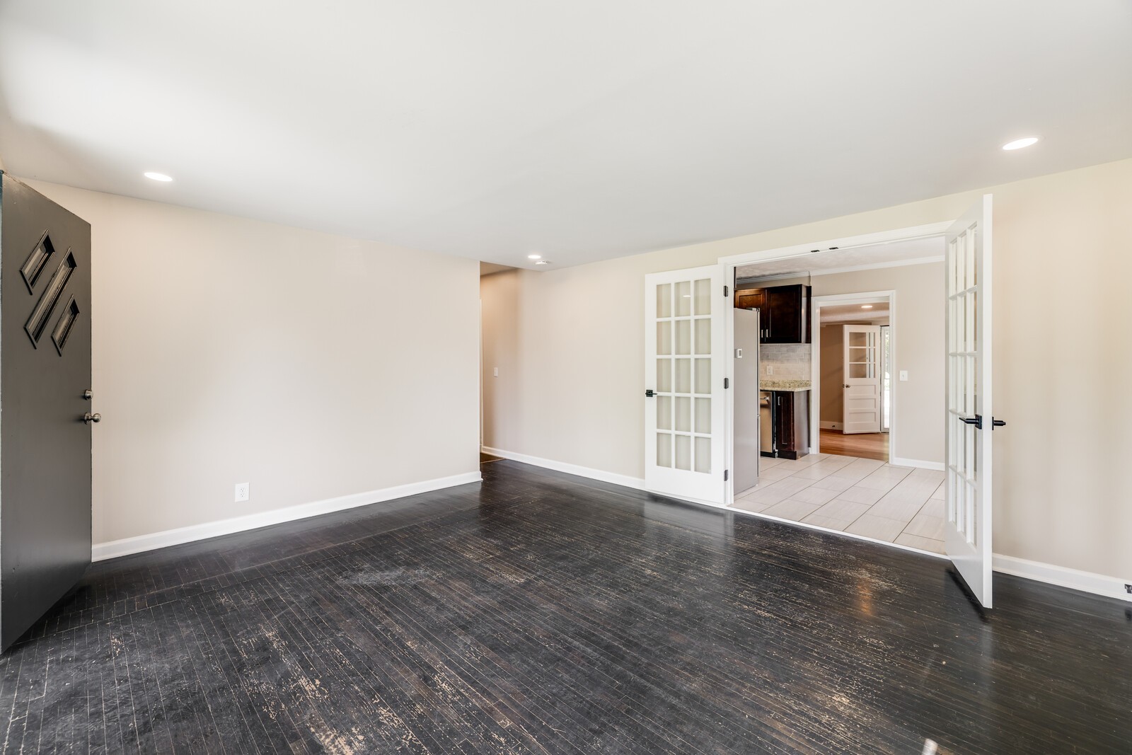 . You'll appreciate the vintage look of the floors. The hall to the left leads to bedrooms and the French doors take you to the kitchen