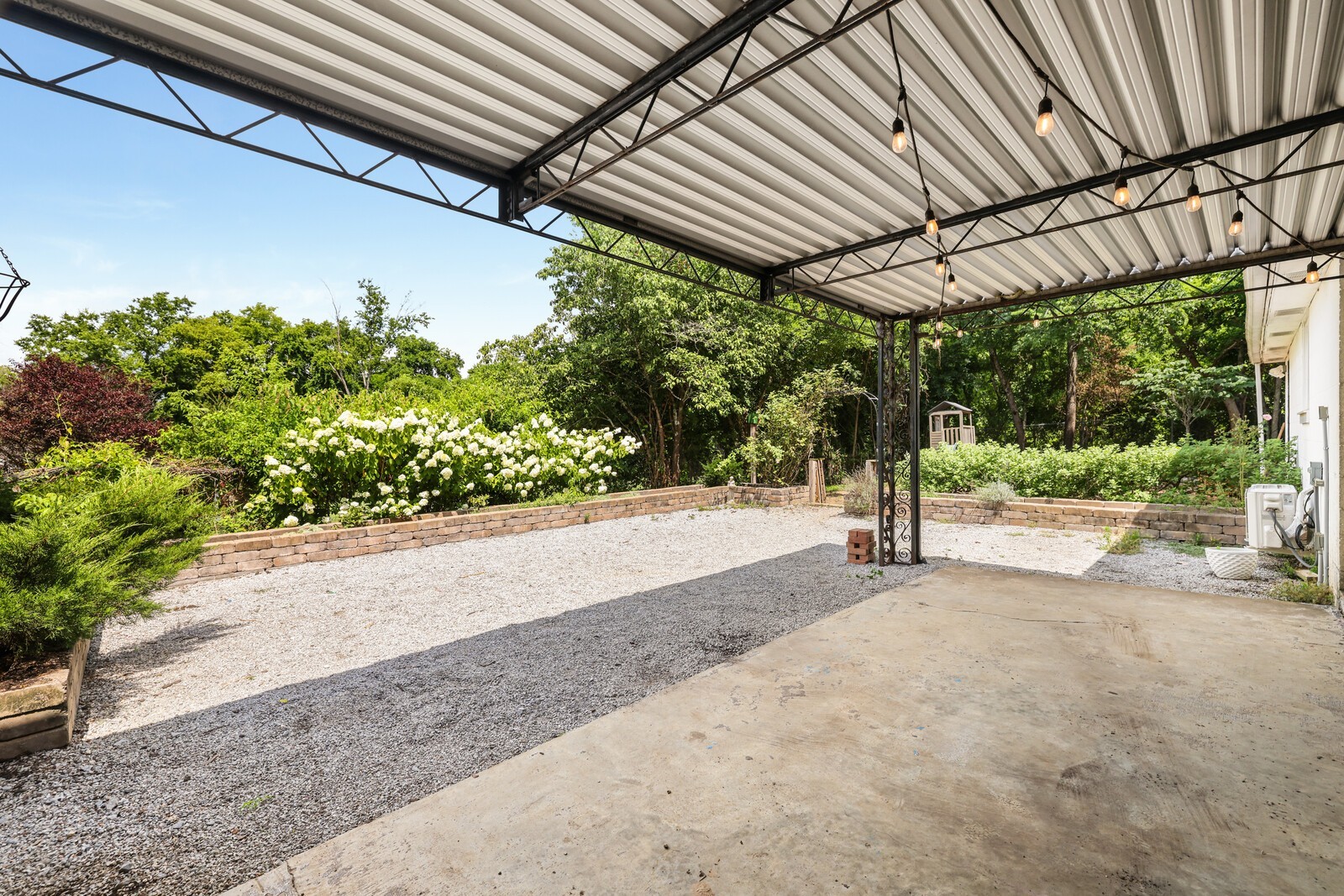 The carport is the gateway to a cute backyard area