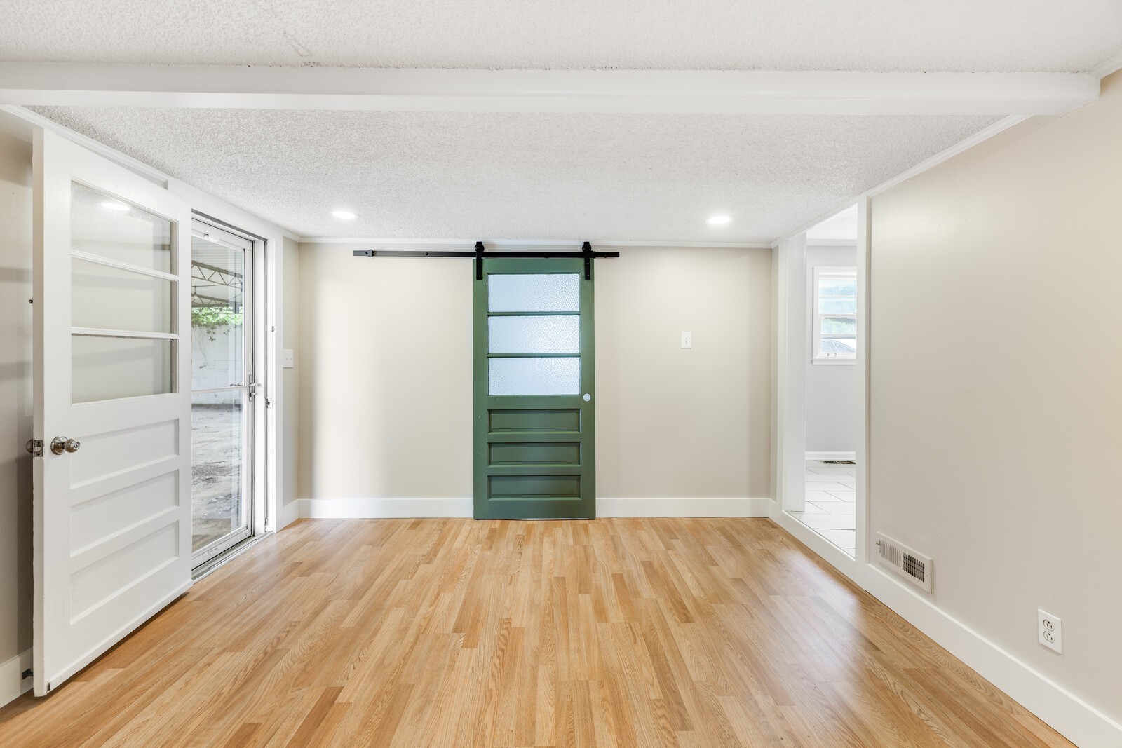 A large flex space between the kitchen and the door to outside--sliding door leads to the laundry space