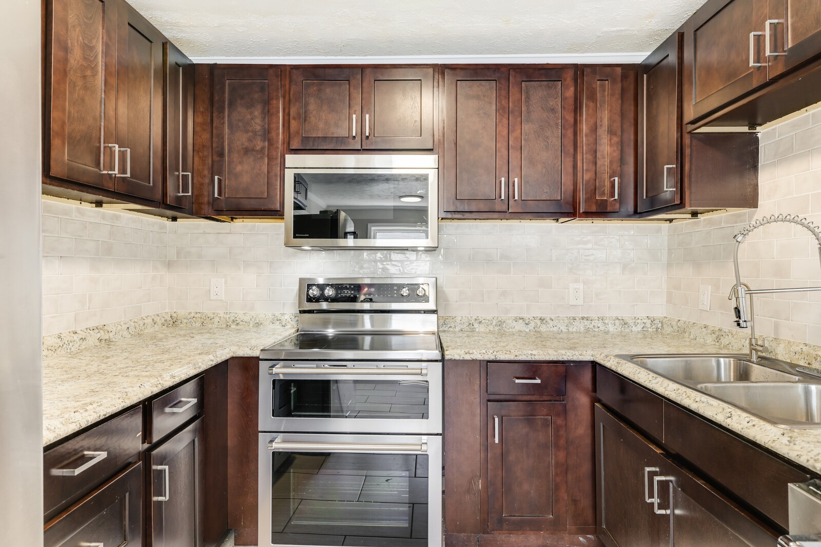 The kitchen boasts SS appliances, tile backsplash and ample storage
