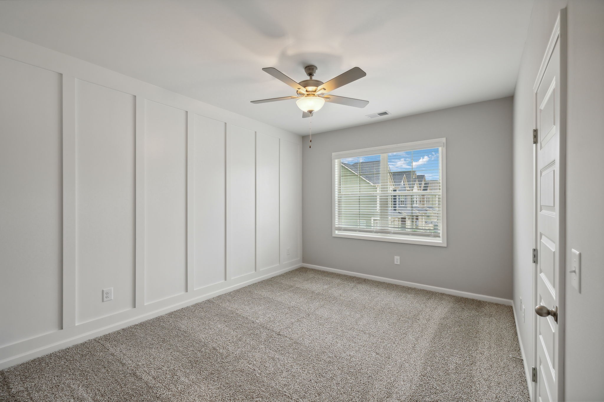 14x11 Primary Bedroom Featuring Judge's Panelling Accent Wall. Photo is of a previously built home with the same floor plan, selections may vary.