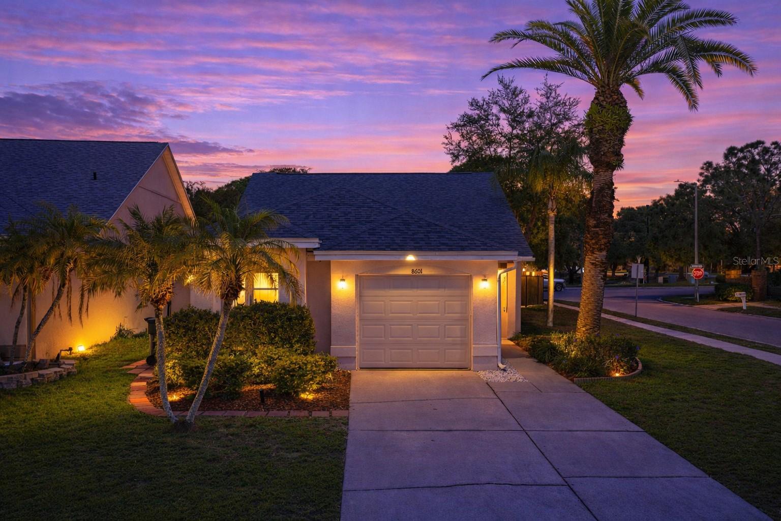 A well-maintained corner lot, a screened side entry surrounded by tropical landscaping, and thoughtful updates throughout highlight this 3 bedroom, 2 bath, 1 car garage home in the established Tampa community of Countryway. The entry offers a warm, private welcome, opening into an expansive living/dining room with vaulted ceilings, transom windows, and a natural flow that feels open without losing a sense of structure. Light moves easily through the main living areas, where luxury vinyl plank flooring carries throughout and a statement fireplace with fluted wall detailing anchors the space with a clean, architectural aesthetic. Sliding glass doors extend the layout into the enclosed sunroom, while a pass-through breakfast bar with upper cabinetry creates a subtle connection to the kitchen, giving you that open feel while still maintaining separation. This well appointed kitchen offers granite countertops, stainless steel appliances, pantry storage, and that functional pass-through makes serving and entertaining into living area a breeze. There is also room to incorporate a dinette, allowing flexibility depending on how the space is used day to day. Positioned separately from the secondary bedrooms, the primary suite offers direct access to the sunroom, a walk-in closet, and an updated ensuite with a modern, cohesive style. Dual sinks with stone countertops, a glass-enclosed walk-in shower, and updated lighting and mirrors give the ensuite a clean, finished feel. On the opposite side of the home, two additional bedrooms provide comfortable accommodations for guests or family, along with a full bathroom that carries through the same updated style. An interior laundry room and attached garage add everyday functionality, while the enclosed sunroom creates an additional area to relax, unwind, or gather. Outside, the fully fenced yard takes full advantage of the corner lot, offering room to spread out, entertain, or simply enjoy the surroundings. Countryway residents have access to a variety of recreational amenities including basketball, tennis, volleyball, soccer, and baseball courts, along with two dog parks and a playground. Optional memberships are also available at the Countryway Golf Club. Do not miss your opportunity to view this home in an excellent location. Call us today for your private tour!