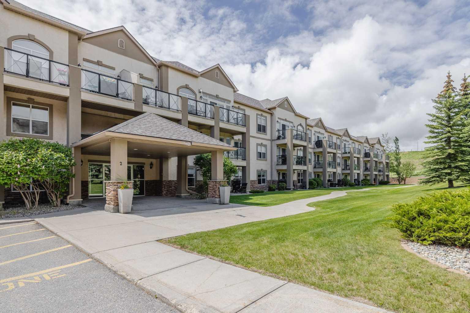 Savor your morning coffee (or evening beverage) on your TOP FLOOR balcony, taking in breathtaking views of parks, the river valley, and the majestic Rocky Mountains! Inside this spacious 1,120 square foot adult living condo, 9’ HIGH CEILINGS allow extra windows creating an airy atmosphere that far outshines standard 8’ units. At the heart of the home is the kitchen with incredible cupboard & counter space, paired with an adaptable dining area that easily transitions from a quiet dinner for two to a family celebration for twelve! The master bedroom easily fits a king size bed with plenty of room for a quiet reading area, and both the ensuite bath and walk-thru closet are also oversized. The versatile second bedroom stands ready as your dedicated craft room, TV lounge, or home office, and it’s conveniently located right next to a full second bathroom. For added peace and quiet, the enclosed in-suite laundry room is intelligently tucked away to keep noise and clutter out of your main living spaces. Year round comfort is a given thanks to radiant in-floor heating to keep your feet warm, and air conditioning to keep you cool.  There's a place for everything thanks to numerous  large closets, storage space in the Laundry Rm and a separate secure storage locker.  If ever the on-site fitness gym, social room, and a courtyard gazebo by a peaceful pond aren’t enough to keep you active, Owners also enjoy full, exclusive access to a private community lake. There you’ll enjoy walking paths, sandy beaches, swimming, boating, fishing, and winter skating. You have worked hard all your life; you deserve a lifestyle of elevated comfort, amazing amenities, security and maintenance-free living this exceptional home provides.