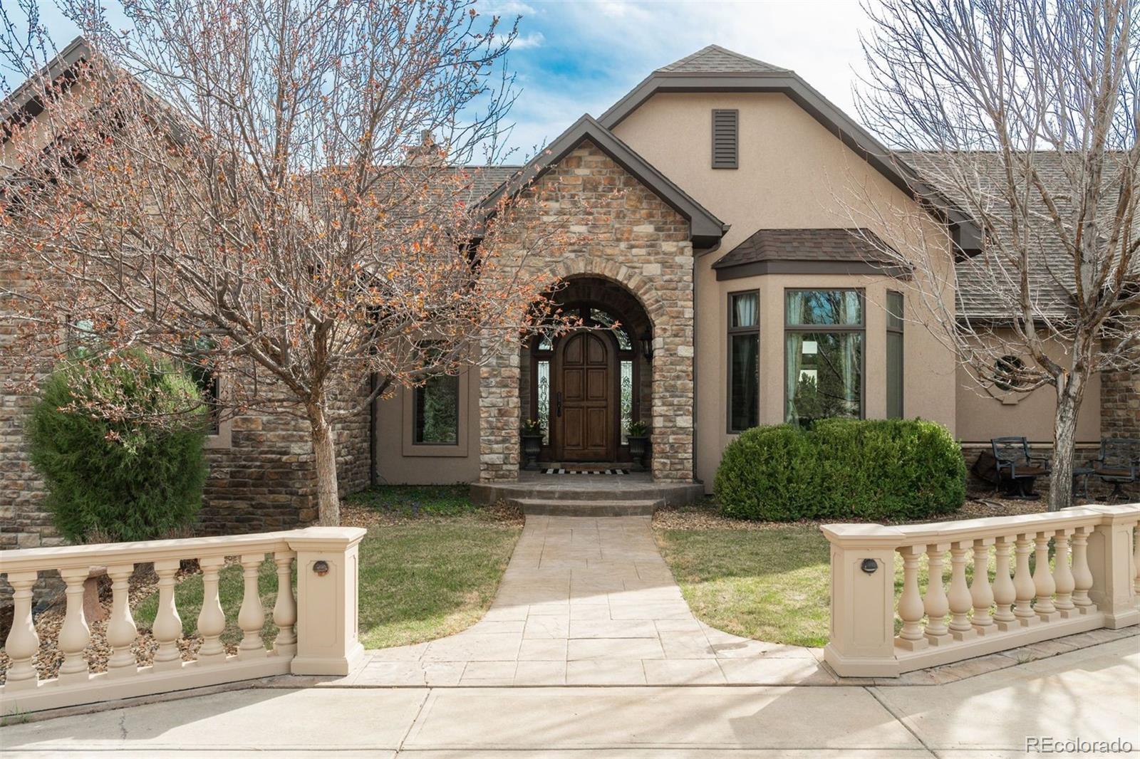 Set on five private, tree filled acres in the sought-after Sterling Tree Farm community, this striking 7,000-square-foot custom home blends modern style with timeless luxury, all framed by unobstructed Pikes Peak views. Thoughtfully designed as an ideal family home, it offers abundant space both inside and out, with plenty of room to live, gather, and play. The main level has been refreshed with updated, contemporary paint tones, creating a clean, elevated aesthetic that complements the rich mahogany detailing throughout. Designed with today’s lifestyle in mind, the layout offers generous, flexible spaces that allow families to spread out comfortably while still feeling connected. A chef-inspired kitchen with a Butler’s pantry anchors the space, while the formal dining room makes a statement. Two expansive main floor bedrooms each feature their own private laundry, offering comfort and convenience with a thoughtful, modern touch. Architectural highlights include a stunning main-level library that adds character and craftsmanship you don’t often find. The lower level is designed for both entertaining and everyday living, with 3 additional bedrooms, a second laundry room, a high end theater, and a beautifully finished secondary kitchen.  A handicap-accessible basement entrance further enhances functionality and ease of access. Outdoor living is equally inviting, with a serene water feature, private patio, and three expansive decks perfectly positioned to take in the mountain views. There’s ample room for outdoor fun, including dedicated spaces to play and a classic horseshoe pit, perfect for gathering with family and friends. The property also includes an oversized four-car attached garage and a 1,800-square-foot outbuilding with a 3-car garage door ideal for storage, hobbies, or a workshop. Private, polished, and perfectly located near Parker, this home delivers space, style, and sophistication.
