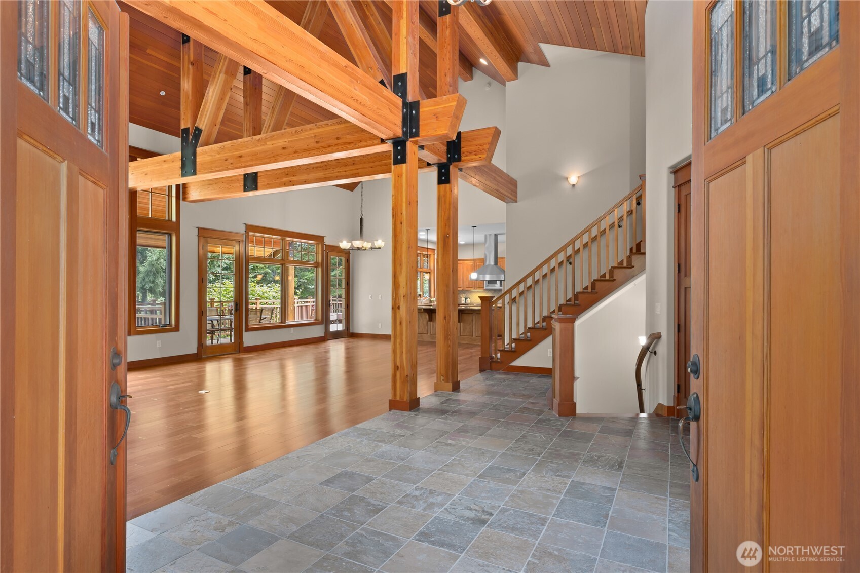 Double doors with stain glass that open up to this great room with incredible beams and a huge stone fireplace.