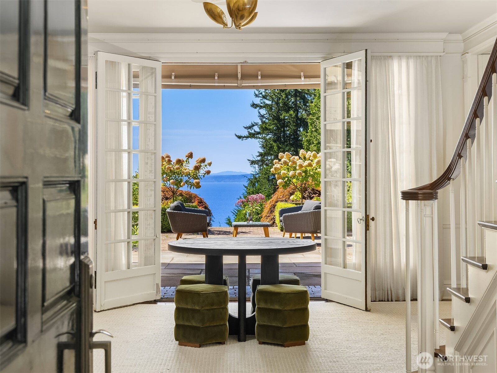 Hidden within the Highlands, this estate is an architectural triumph. A gated entry leads to a grand entrance, exuding unparalleled luxury & privacy. This Colonial Revival spans expansive grounds w/ lush gardens, a waterfall & outdoor spaces offering panoramic Puget Sound views. Sunlight fills large windows, highlighting refined details. The kitchen features marble counters, integrated appliances, dual sinks & walk-in pantry, flowing into a great space w/ fireplace. The primary suite offers dual bathrooms, ample storage & ocean views. Upstairs, lofty bedrooms w/ private balconies. Additional features include: indoor sports court, terracotta wine cellar, theatre, outdoor kitchens, hot tub, gardening plots & fully equipped guesthouse.