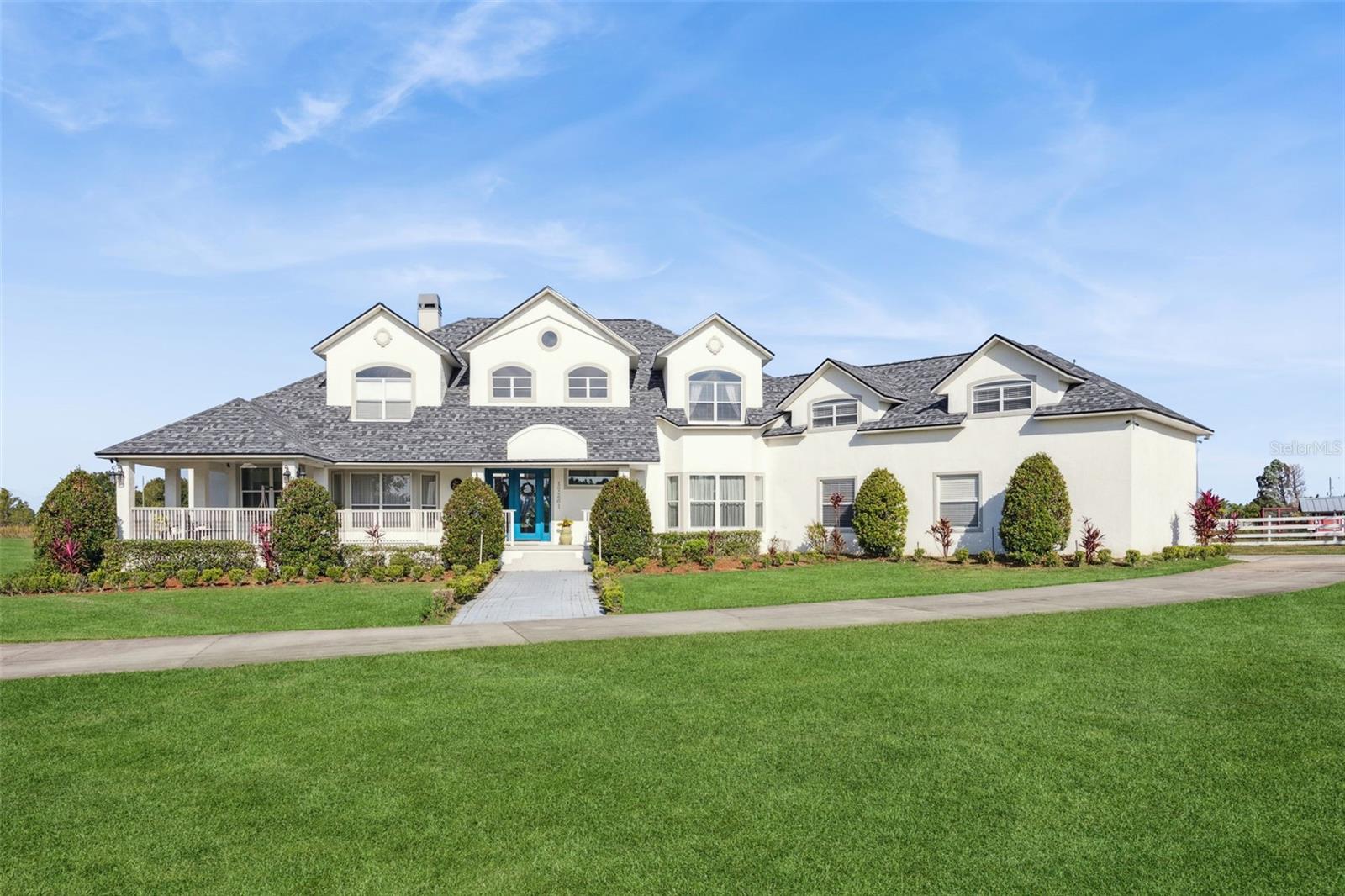 Discover Winter Garden’s best-kept secret in Avalon Estates, a peaceful, horse-friendly enclave where timeless country charm meets modern luxury. This custom-built residence offers an impressive 6,400 sq. ft. under air and nearly 10,000 sq. ft. under roof, set on 4.6 picturesque acres surrounded by nature and serenity.
From the moment you arrive, the inviting curb appeal and sprawling front porch set the tone for what awaits inside. Step through the double entry doors into a grand living space filled with soaring ceilings, abundant natural light, and an airy, open feel that defines Florida living at its finest.
The modern farmhouse kitchen is a dream for entertaining, featuring two expansive islands, generous counter space, and seamless flow into the family room, where a wood-burning fireplace adds warmth and charm. French doors open to the pool area, complete with two oversized covered lanais, creating an ideal setting for relaxing or hosting guests.
The downstairs primary suite is both spacious and inviting, featuring a private fireplace, large walk-in closet, and a magazine-worthy en suite bath. A private office sits just off the primary suite, offering a quiet retreat for work or study.
Upstairs, you’ll find a large bonus room with kitchenette, three additional bedrooms, and two full bathrooms—perfect for family or guests. Don’t miss the panoramic views through the large windows—on clear nights, you can watch Disney fireworks sparkle in the distance and even catch NASA rocket launches from the east coast.
Built with poured concrete tilt-wall construction, this home is as strong and resilient as it is beautiful. The laundry room doubles as a safe room, featuring metal doors, bullet-resistant glass, and reinforced concrete walls and ceiling.
Additional highlights include a new roof (2025), an attached three-car garage, plus a detached 2.5-car garage with studio and full bath—ideal for guest quarters, an office, or hobby space.
Located just minutes from shopping, dining, and major highways (Florida Turnpike, 429, and 408), this estate is 11 miles from Disney World, 12 miles from Universal Studios, and 23 miles from Orlando International Airport.
With its combination of space, craftsmanship, and location, this property also offers excellent potential as a luxury short-term rental.
Experience the tranquility and grandeur of Avalon Estates—schedule your private tour today and start creating lifelong memories in your new home.