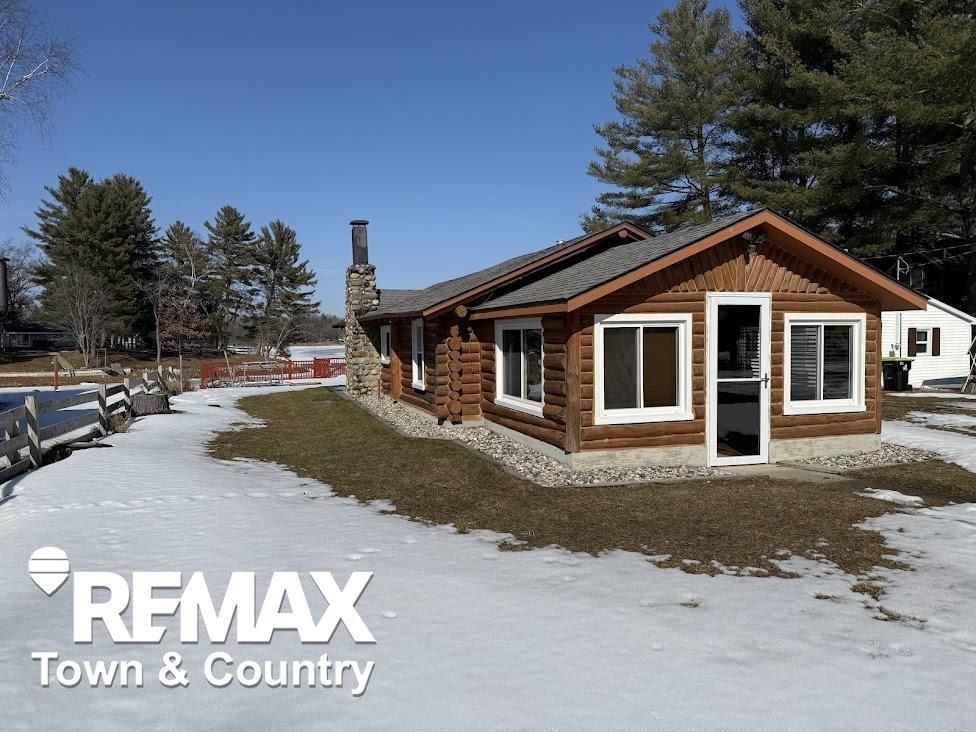 This stunning true log home showcases authentic log walls inside and out, anchored by a striking stone chimney that sets the tone the moment you arrive. Inside, the inviting great room features a cozy wood-burning fireplace and flows effortlessly into the updated kitchen, creating the perfect space for relaxing or entertaining.  The home offers two comfortable bedrooms, a full bath, and a charming tiki shed that provides additional sleeping space for guests. First-floor laundry adds everyday convenience, while thoughtful updates throughout ensure peace of mind.  Step outside and fall in love with the expansive, newly built multi-tier deck featuring built-in storage beneath, ideal for lake living. Enjoy countless evenings on the large covered patio overlooking the water, complete with a brand-new firepit for unforgettable nights under the stars.  Major improvements include a new well, new electrical, new seawall, new irrigation system, and a Culligan water system providing endless water. A finished 24x24 two-car garage with opener offers plenty of space for vehicles and lake toys.   Secord Lake is scheduled to return to full capacity between June and September 2026, making this an exceptional opportunity to own a beautifully updated lakefront getaway just in time to enjoy it all.
