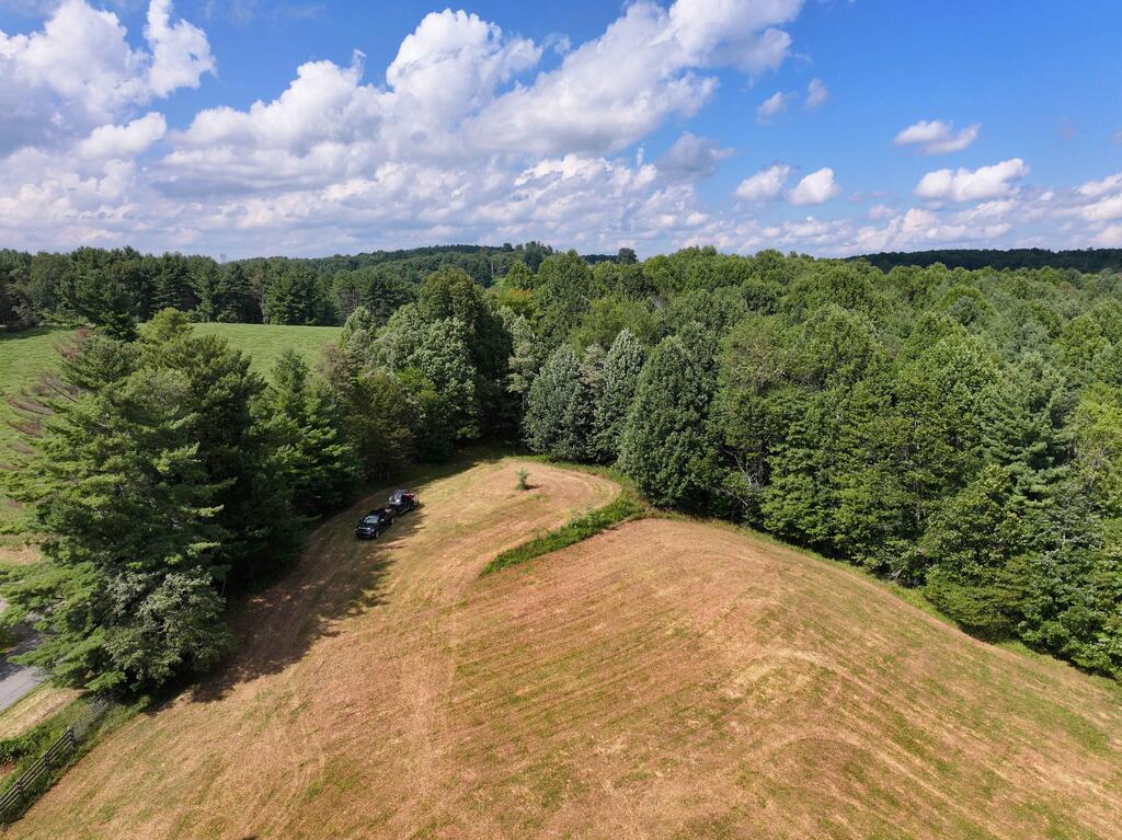 Located along peaceful Shady Grove Road NW in western Floyd County, this 44+/- acre tract offers wooded privacy, 3,000'+/- of flowing creek frontage, established trails, abundant wildlife habitat, & approximately 1 acre of open pasture with potential for a homesite. A gated entrance off Shady Grove Road provides access, with fencing already in place along the road. The upper pasture area offers a great vantage point looking southward across the surrounding rolling countryside, while the remainder of the property transitions into a park-like setting of mature woods featuring towering pine, poplar, oak & other various hardwoods, with ferns, rhododendron, natural creek crossings, & numerous established trails for ATVs, UTVs, Jeeps, horses, mountain bikes, hiking, & exploring. Deer trails & abundant wildlife sign are present throughout the woods, while the flowing creek creates additional recreational appeal. The property offers great potential to transform into a private hunting retreat, weekend recreation property, mountain biking or equestrian property, rural homestead, or secluded mountain getaway, with the opportunity to create a homesite within the existing pasture, or you could clear a portion of the woods for a more private setting. Approx 20 min to downtown Floyd & Hillsville, with easy access to I-77 & surrounding Blue Ridge communities. A contiguous 22+/- acre tract is also available for sale, if you're looking for more pasture and overall acreage. Shown by appointment.