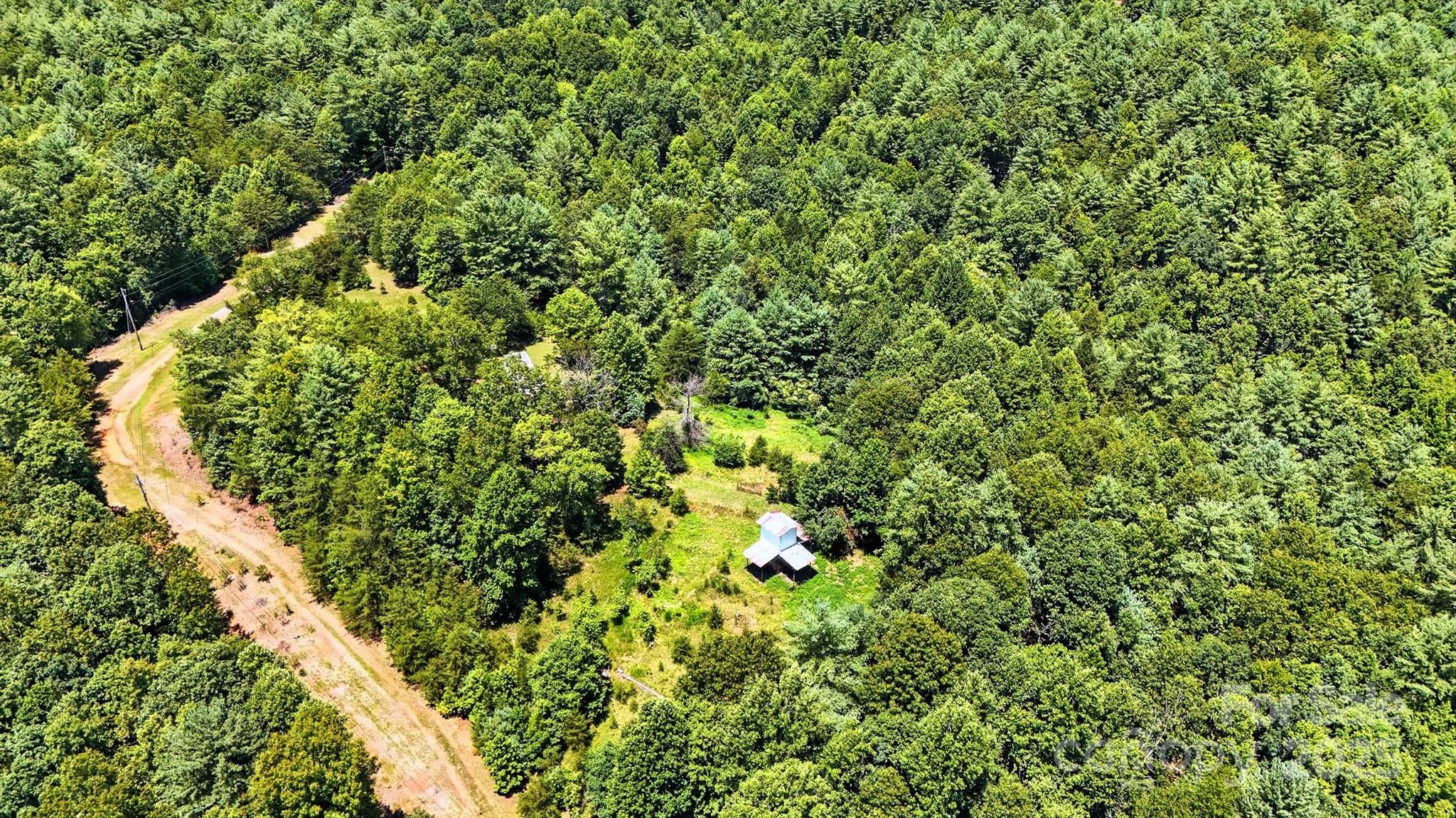 This remote three parcel property is perfect for anyone seeking a private existence. Where neighbors are spread out and the land is unrestricted. Very little value is being given to the home as it would need to be renovated to live in or stay in while a home is built. You'll find fencing and several structures which may prove beneficial if a homestead is the goal. A long dirt road leads to the property. Due to the age of the manufactured home, the property likely will not qualify for financing. The seller makes no representations as to the functioning of any systems related to the home or appliances. Selling As-Is. Tanning bed will convey with the home.