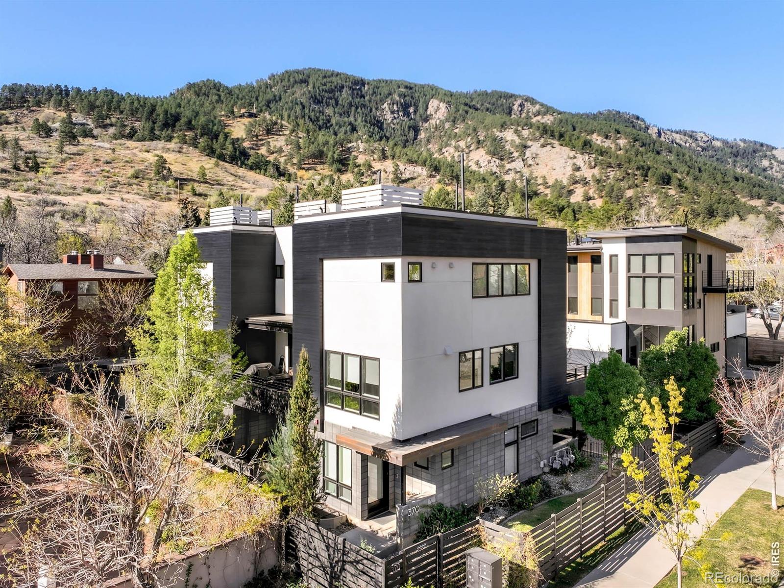 Perched in Boulder's coveted West End, this exceptional south-end townhome captures sweeping mountain and city views across four thoughtfully designed levels. Bathed in natural light, the residence offers a seamless blend of modern design and functional living. A flexible main-level bedroom or office opens to a private patio, while the second level unfolds into an expansive, sunlit living and dining area, opening to a west-facing balcony with retractable awning. The chef's kitchen features premium Miele appliances, quartz countertops, and a striking waterfall island. The upper level is dedicated to a serene primary suite with a walk-in closet, spa-inspired bath, and private balcony. A lower-level flex space provides additional versatility for guests, fitness, or recreation. Outdoor living is unmatched, with multiple terraces culminating in a rooftop deck complete with a hot tub and panoramic views of Flagstaff Mountain, Mount Sanitas, the Flatirons, Red Rocks, and the city below. Thoughtful upgrades include automated window coverings, an integrated sound system, refinished hardwood floors, and secure parking with EV charging.Ideally located just moments from Viewpoint and Settlers Park trailheads, this residence offers immediate access to Boulder's premier outdoor lifestyle while remaining close to Pearl Street and downtown amenities.