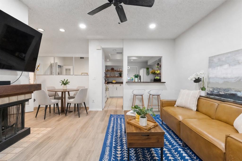 This beautifully renovated, rarely available first-floor Mediterranean-style condo offers a highly sought-after floor plan with two bedrooms and two full bathrooms—perfect for a convenient, single-level, move-in-ready lifestyle. The open-concept living and dining areas are anchored by a charming corner wood-burning fireplace, creating a warm and inviting atmosphere. Stylish, low-maintenance luxury vinyl plank flooring runs throughout, enhancing both durability and design. The kitchen is thoughtfully redesigned with updated cabinets with custom shelving for both display and storage, a breakfast bar for additional seating, and a pass-through window that makes entertaining effortless. Both bathrooms have been tastefully remodeled with new vanities, mirrors, lighting, and beautiful tile finishes. French doors open to a spacious primary suite featuring a walk-in closet, plantation shutters, and a dual vanity—ideal for busy mornings. The secondary bedroom offers a vaulted ceiling, plantation shutters, and its own beautifully updated ensuite bath. Additional features include ceiling fans in both bedrooms, the living room, and even the private patio—perfect for relaxing outdoors. The attached one-car garage provides extra storage space and convenient access. Residents enjoy community amenities including a pool and hot tub, while the affordable HOA covers water, sewer, trash, exterior insurance, and grounds maintenance for added peace of mind. Ideally located near LBJ Freeway and the Tollway, this home combines comfort, style, and convenience. Don’t miss your opportunity to make this condo gem yours -schedule your showing today!