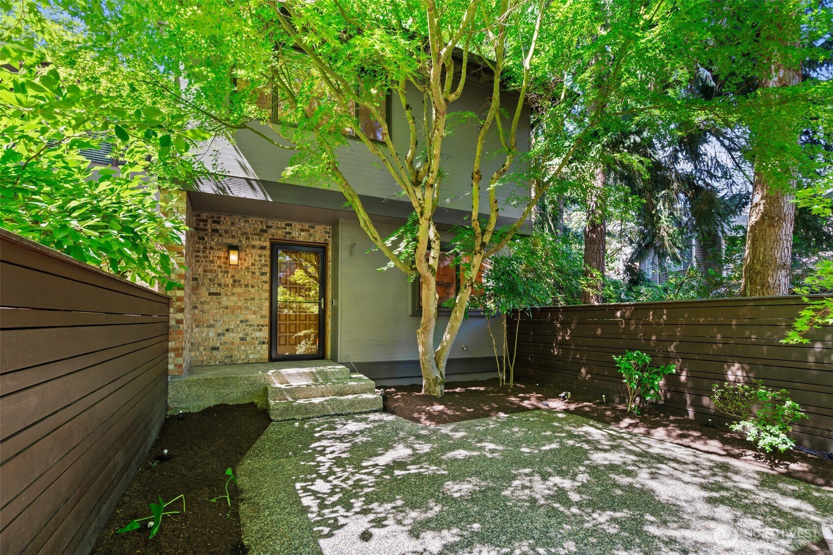 Inviting private entrance framed by mature landscaping and a peaceful courtyard.