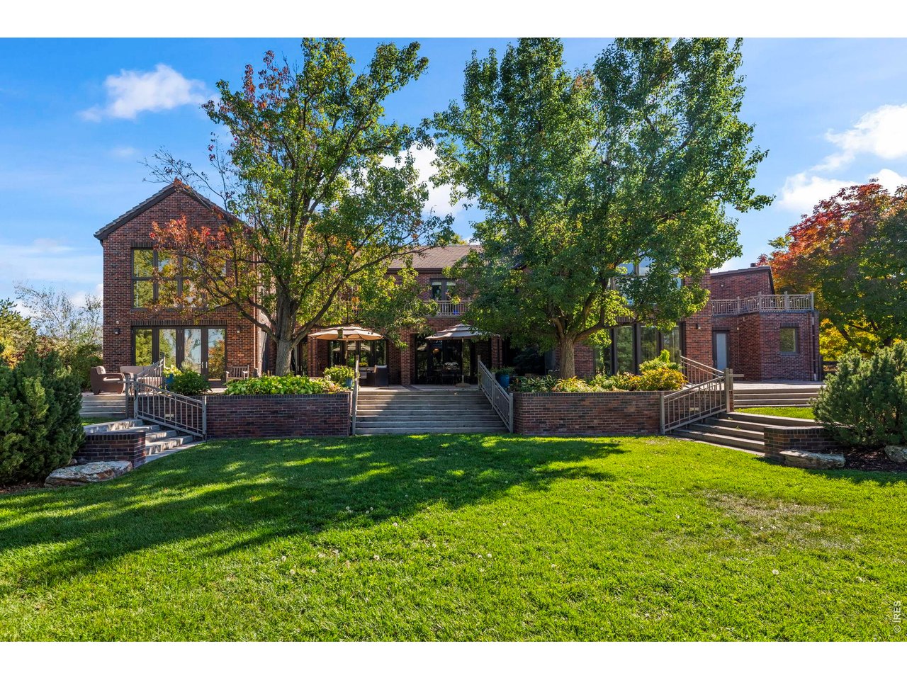 Set on one of the most coveted lots in prestigious Somerset Estates, this exceptional estate offers a rare blend of privacy, scale & sweeping Front Range views. Tucked at the end of a private cul-de-sac on 1.10 ACRES, the home is introduced by a circular drive and covered entry, setting the tone for the refined interiors within. A striking double staircase defines the foyer, leading to expansive living & entertaining spaces. The grand 2-story living room features soaring ceilings, a statement fireplace, and wall of windows that frame the surrounding landscape. Just beyond, a dedicated home theater w/ built-in seating creates the ultimate setting for movie nights. The gourmet kitchen is thoughtfully designed for both everyday living & elevated entertaining, complete with center island & Thermador appliances-including gas range & walk-in pantry. Adjacent spaces include a family room w/ fireplace & serene sunroom wrapped in windows, offering uninterrupted views year-round. Upstairs are 4 generously sized bedrooms w/ ensuite baths for optimal comfort & privacy. The luxurious primary suite serves as a private retreat, with a view deck, fireplace w/ stone surround & 6-piece bath featuring a large walk-in steam shower, dual vanities & jetted tub. Impressive walk-in closet w/ rich custom built-ins connects to a private executive office with its own powder bath. A 2nd primary suite with 5-PC bath provides ideal accommodations for guests, extended family, or nanny. The lower level offers a versatile space perfect for home gym or studio, along with abundant storage. Car enthusiasts & hobbyists will appreciate the oversized, heated 4-car garage with convenient access to multiple mudrooms. Multiple patios & beautifully curated landscaping create an ideal backdrop for entertaining or simply enjoying Colorado's natural beauty. Ideally located minutes from charming downtown Niwot, an extensive network of trails, and top-rated schools. This is Colorado living at its finest.