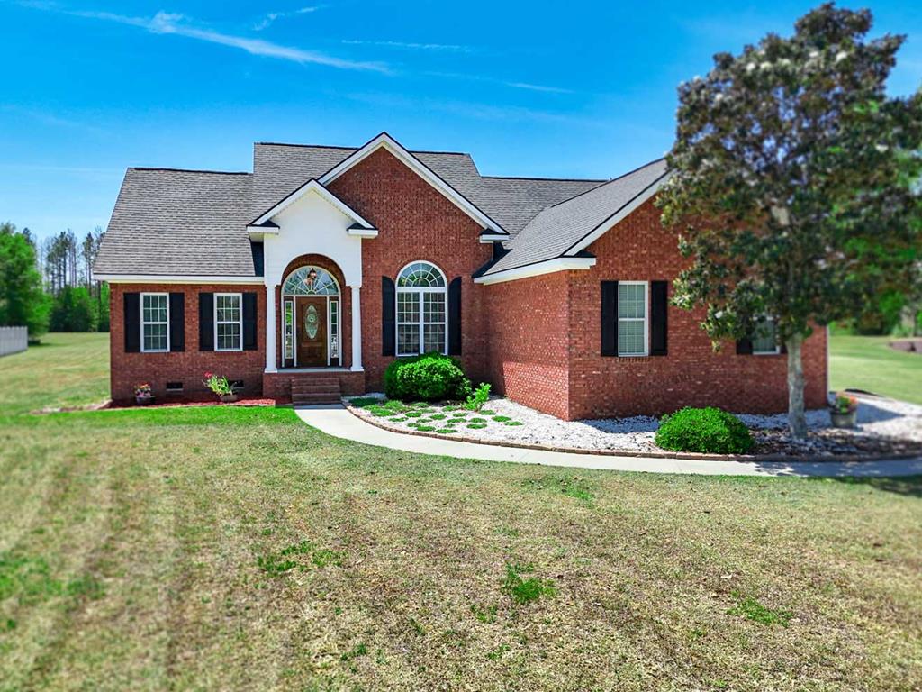 Welcome to this beautiful brick home in the sought after Heards Pond community! This thoughtfully designed 3-bedroom, 2-bath home offers 1,647 square feet of modern living space with the perfect blend of comfort and style. Inside, you'll find a bright, open layout featuring gorgeous soaring ceilings, luxury vinyl flooring, and a stunning kitchen with hard surface countertops, stainless steel appliances, and an electric range—perfect for both everyday living and entertaining. The primary suite is a true retreat, complete with a trey ceiling, a luxurious tiled garden tub, a separate shower, double vanity, and a spacious walk-in closet. The additional bedrooms offer flexibility for family, guests, or a home office. This home also includes a 2-car garage which provides practical space for extra storage. Relax outside under the covered back porch while enjoying the privacy and space of your large 1.2 acre lot. Located in Heards Pond, this home offers a peaceful setting with convenient access to nearby amenities. Recent updates to the home include a new roof (2025), new outside A/C unit (2025), and a recently serviced septic tank (2025).